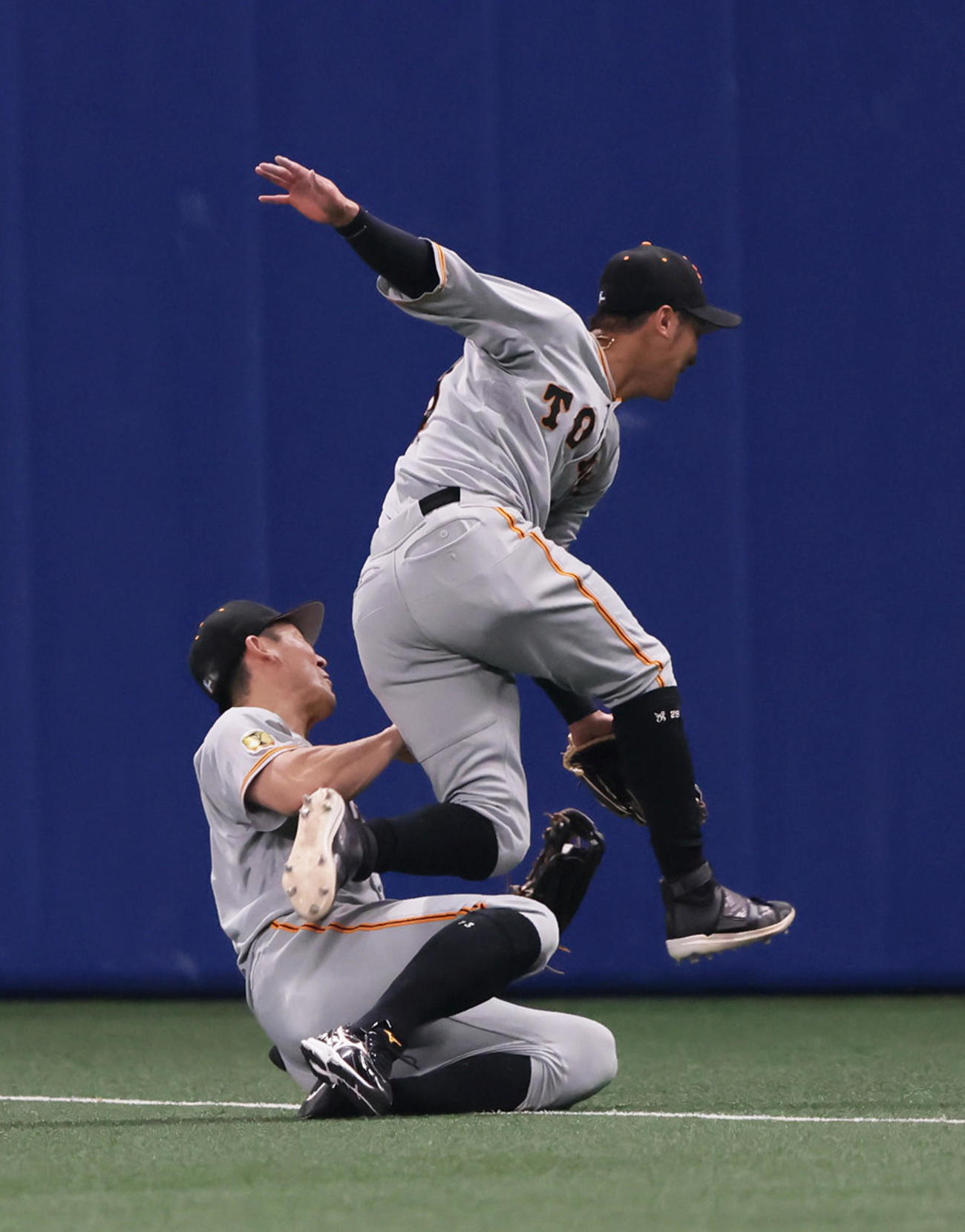 中日対巨人　3回裏中日1死二塁、ビシエドの打球を捕球した際に負傷する右翼手梶谷（左）。右は二塁手吉川（撮影・足立雅史）