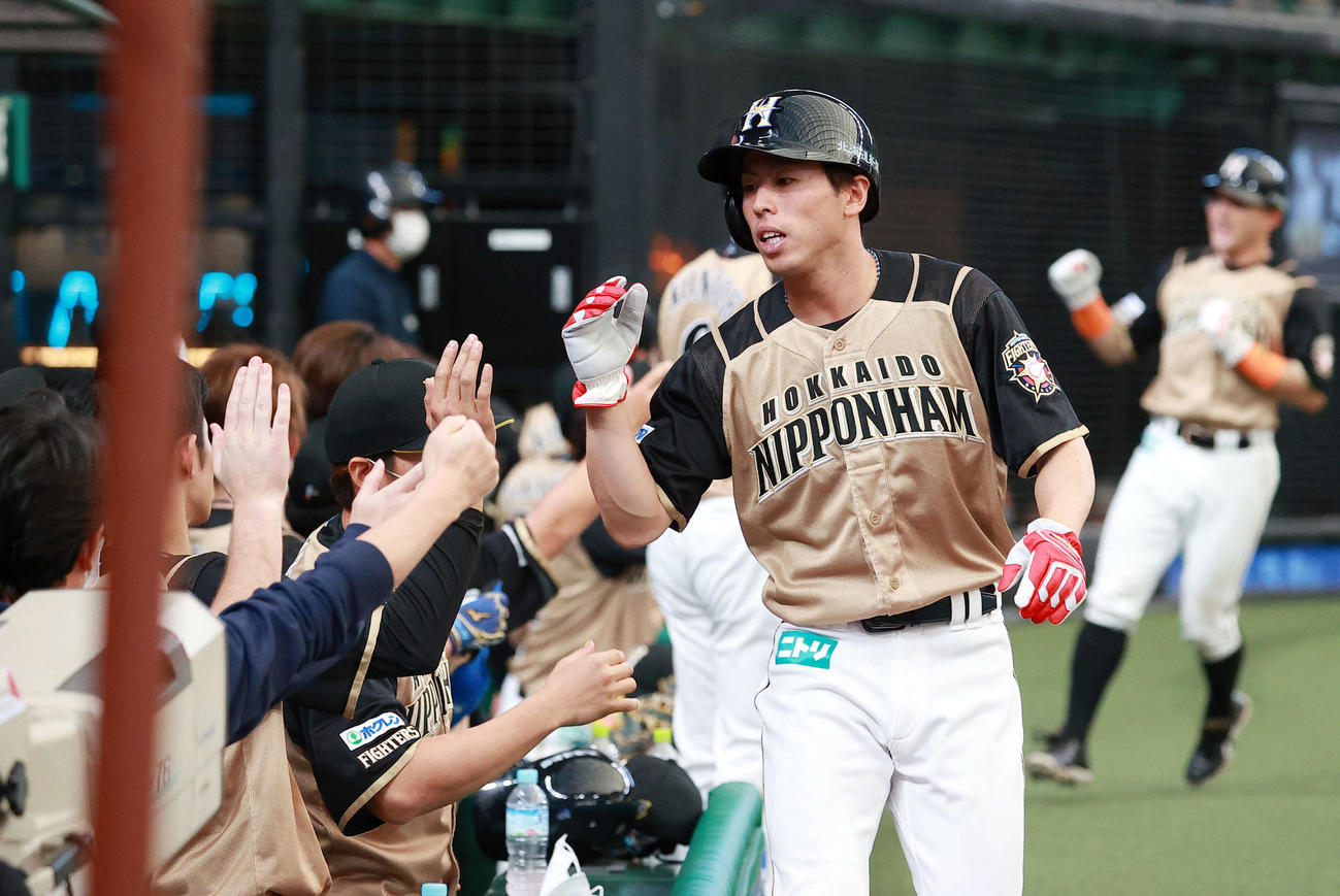 西武対日本ハム　8回表日本ハム1死満塁、西川の2点右適時打で生還した五十幡（右）はナインとハイタッチ（撮影・浅見桂子）