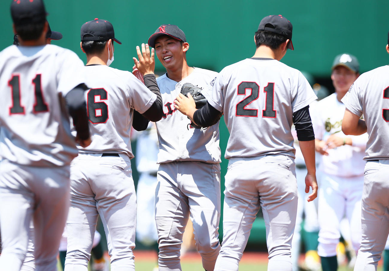 日大対専大　完封勝利を飾り笑顔でタッチを交わす日大・赤星（中央）（撮影・足立雅史）