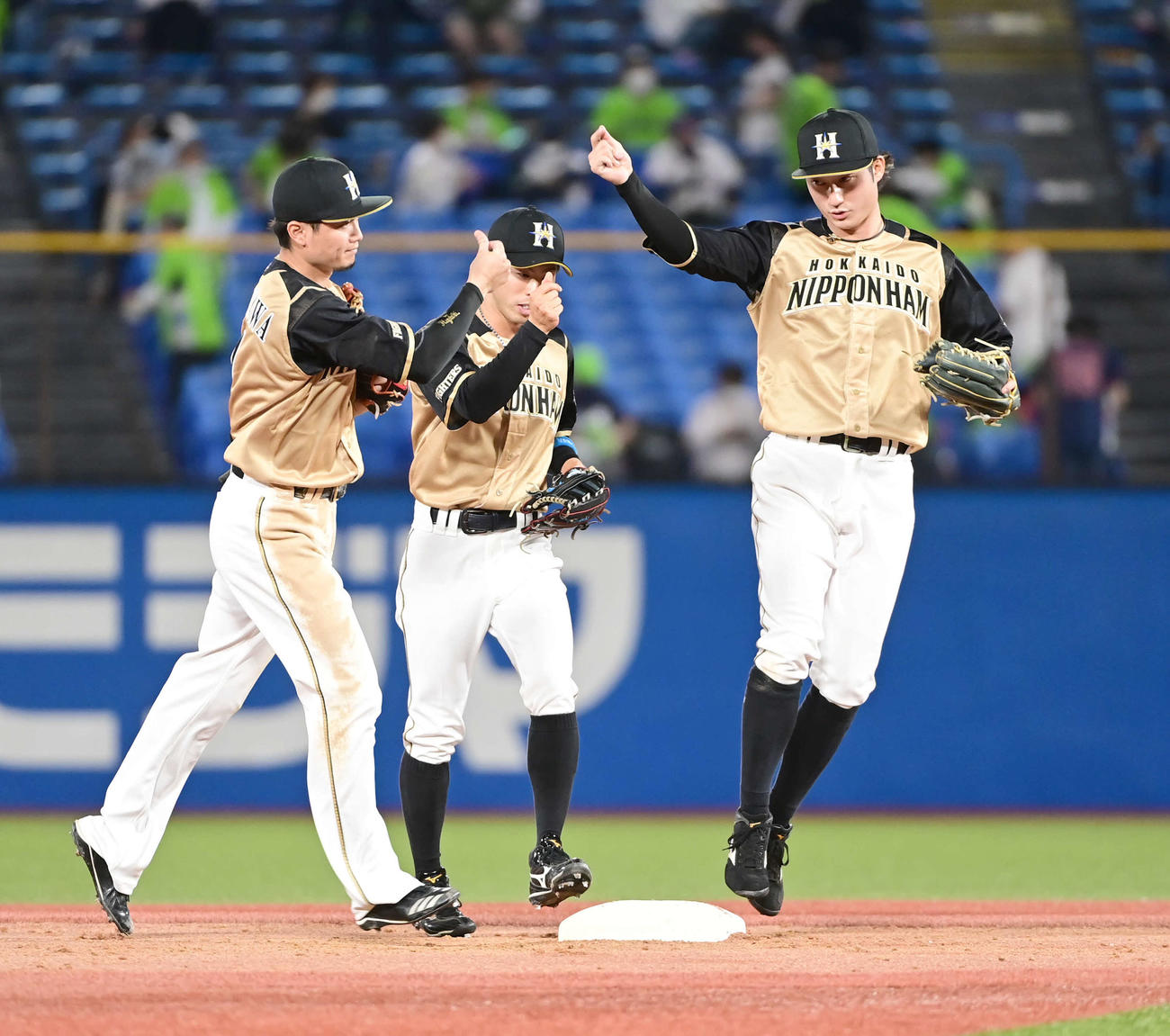 ヤクルト対日本ハム　勝利に沸く日本ハムの、左から西川、五十幡、浅間（撮影・小沢裕）
