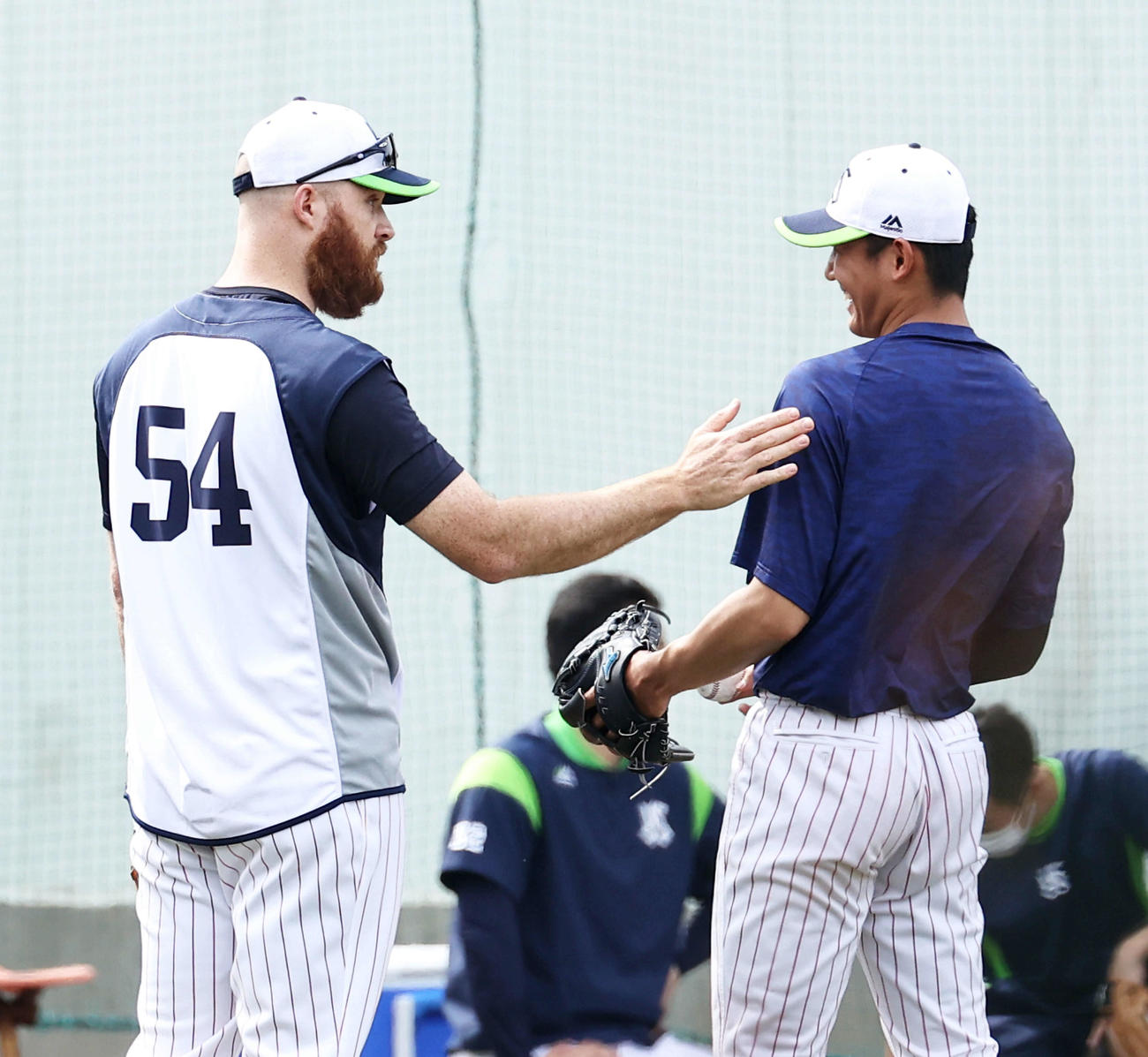 ヤクルト対日本ハム　試合前、球を受けたサイスニード（左）と笑顔で言葉を交わすヤクルト奥川（撮影・河田真司）
