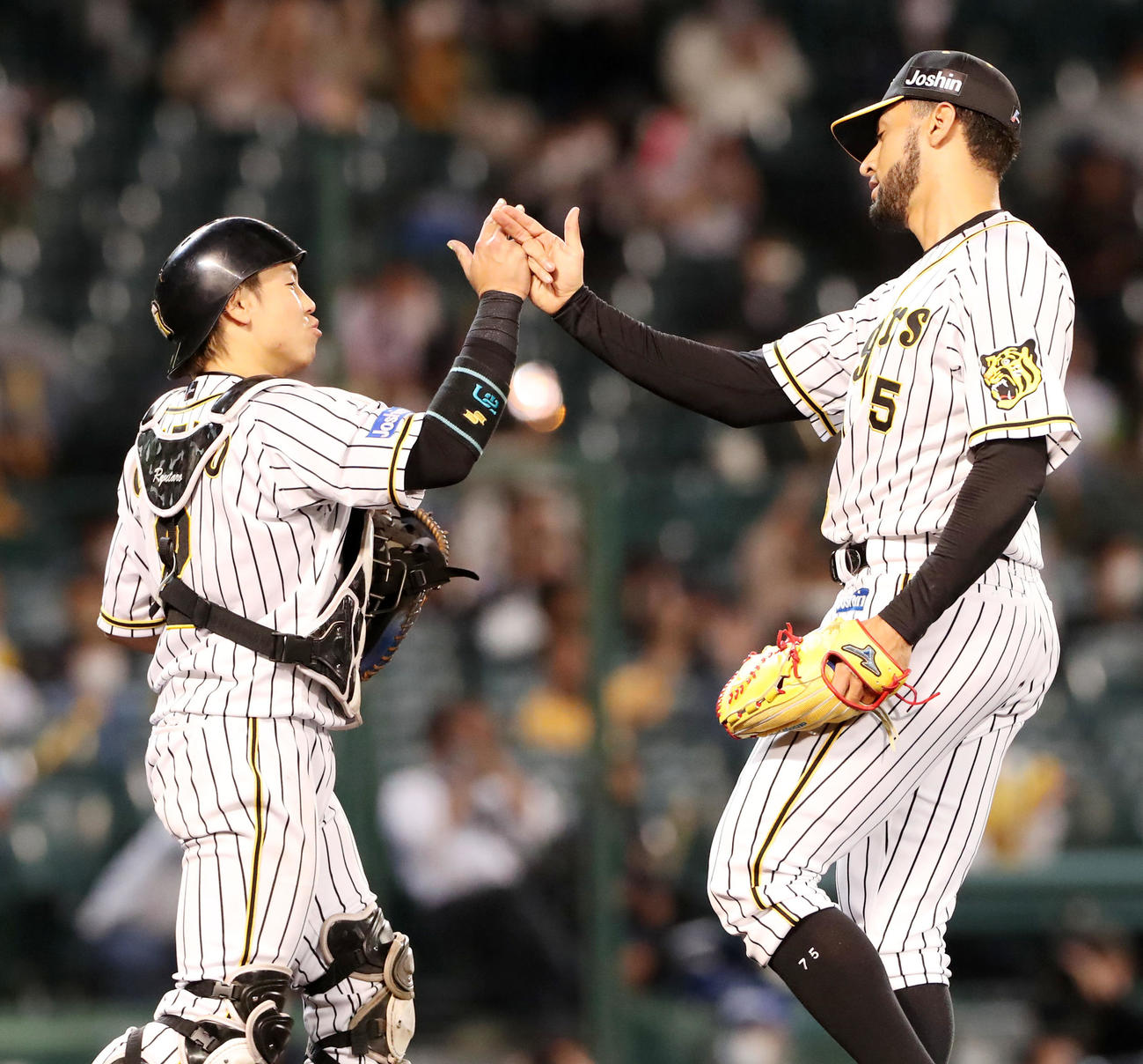 阪神対ロッテ　ロッテに勝利し梅野（左）とタッチするスアレス（撮影・加藤哉）