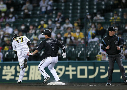 阪神対ロッテ　6回表阪神2死二塁、藤岡（中央）の打球で一塁手マルテがベースカバー岩貞（左）に悪送球し失点する（撮影・上山淳一）