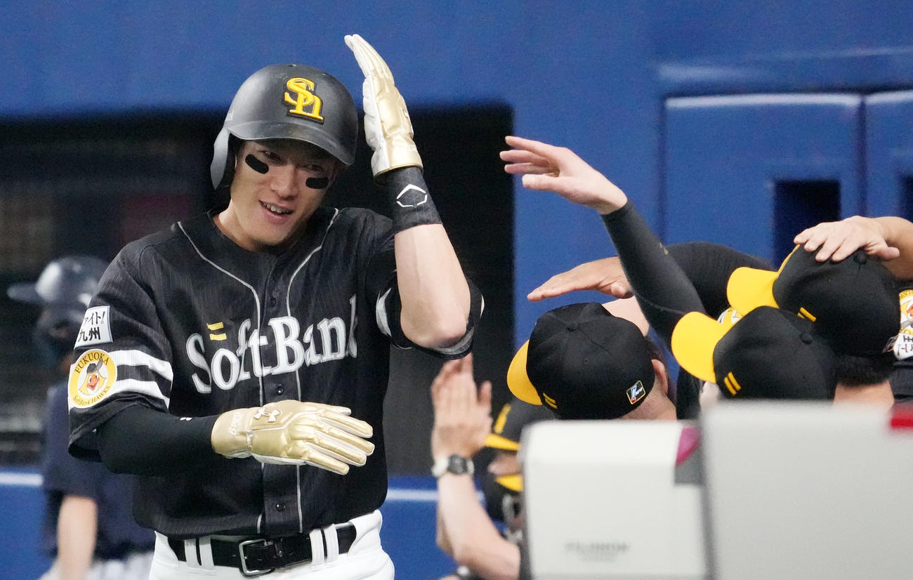 中日対ソフトバンク　1回表ソフトバンク2死一、二塁、上林の左前打で生還しナインとタッチを交わす柳田（左）（撮影・森本幸一）