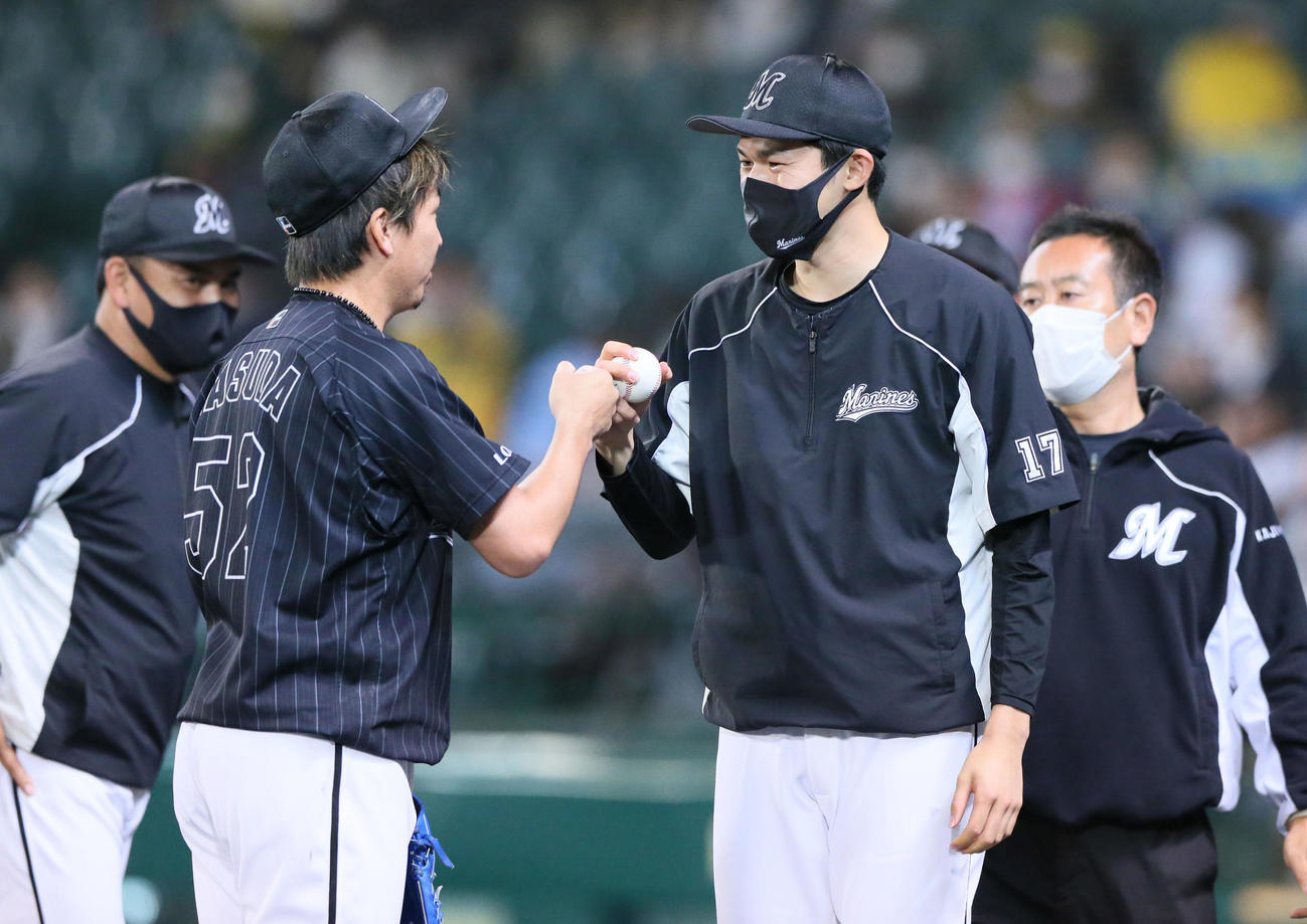 阪神対ロッテ　ロッテ佐々木朗（右から2人目）は益田（左から2人目）からウイニングボールを受け取り笑顔でグータッチする、左は井口監督（撮影・上山淳一）