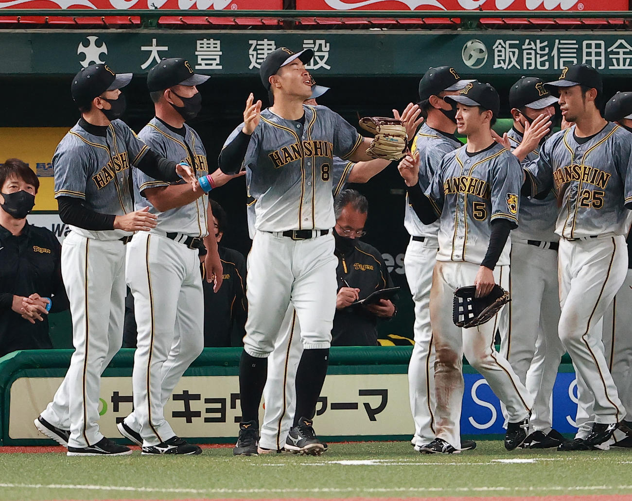 西武対阪神　井上一樹ヘッドコーチ（左から2人目）に頭をたたかれおどける阪神佐藤輝。左端は矢野監督（撮影・野上伸悟）