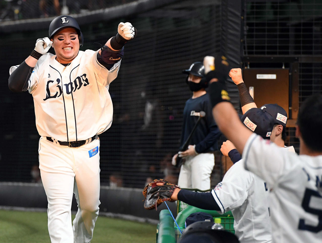 西武対阪神　2回裏西武1死、先制のソロ本塁打を放った山川は、ナインの出迎えに笑顔でポーズを決める（撮影・たえ見朱実）