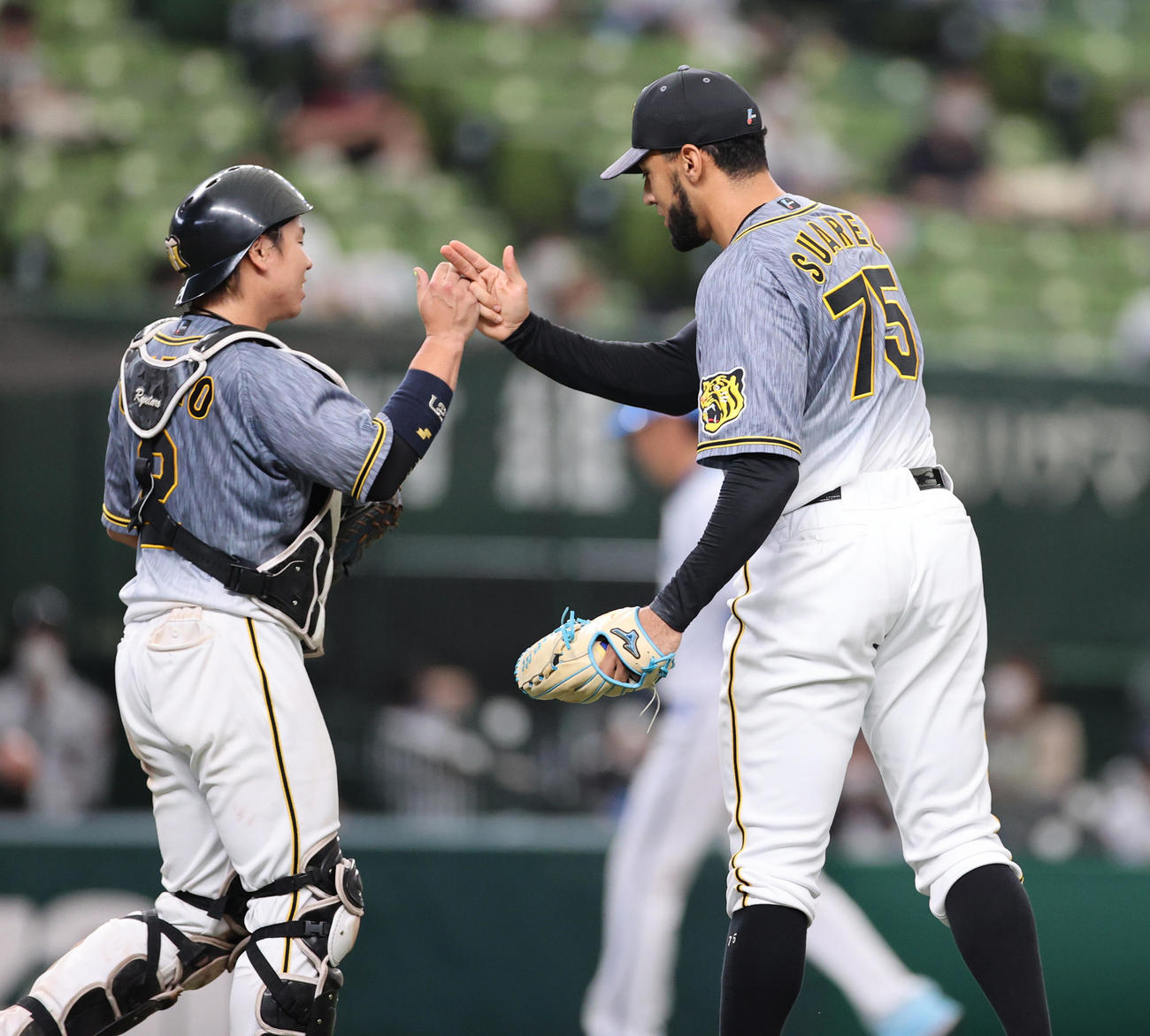 西武対阪神　9回、最後を締めタッチを交わす捕手梅野（左）とスアレス（撮影・清水貴仁）