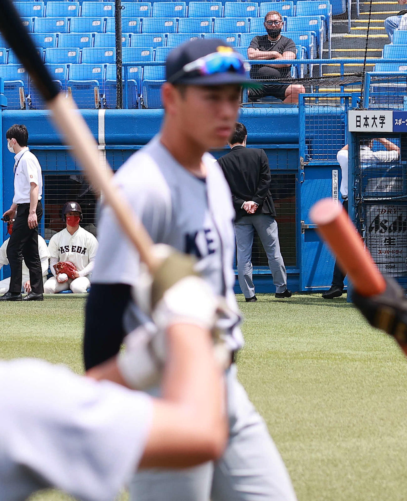 慶大対早大　試合前、ベンチ前に素振りに出てきた慶大清原（手前）を奥から見つめる清原和博氏（撮影・浅見桂子）