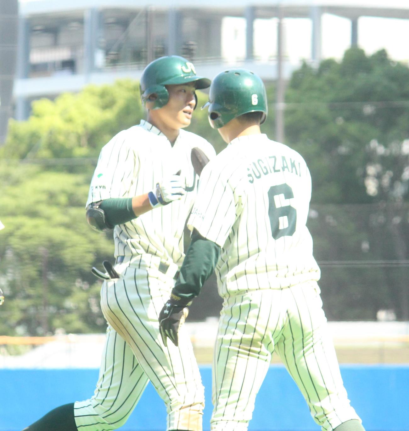 JR東日本対エイジェック　延長10回表JR東日本無死一塁、決勝2ランを放ちハイタッチをする菅田（左）（撮影・保坂恭子）