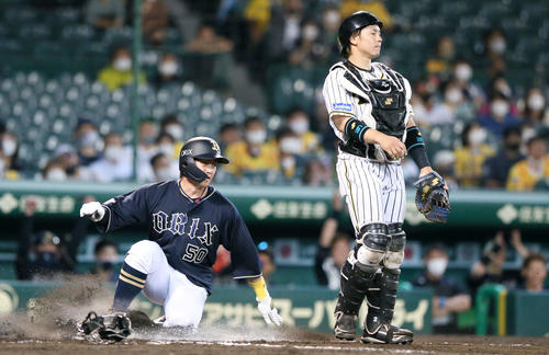 阪神対オリックス　8回表オリックス2死一、二塁、安達了一の中前適時打で二走小田裕也（左）が生還する。右は梅野隆太郎（撮影・上山淳一）