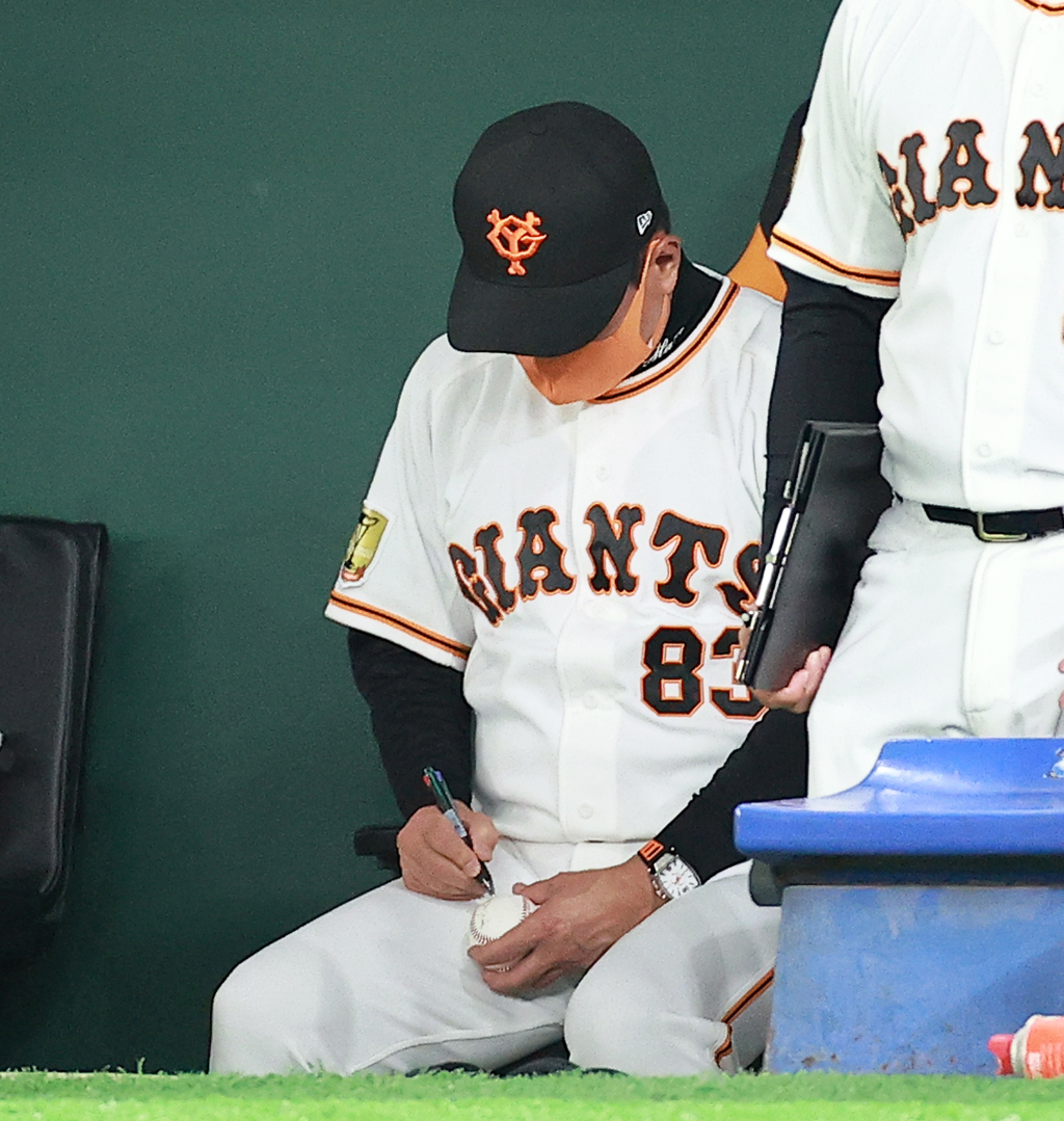 試合中、サインボールを丁寧に書く巨人原監督（撮影・浅見桂子）