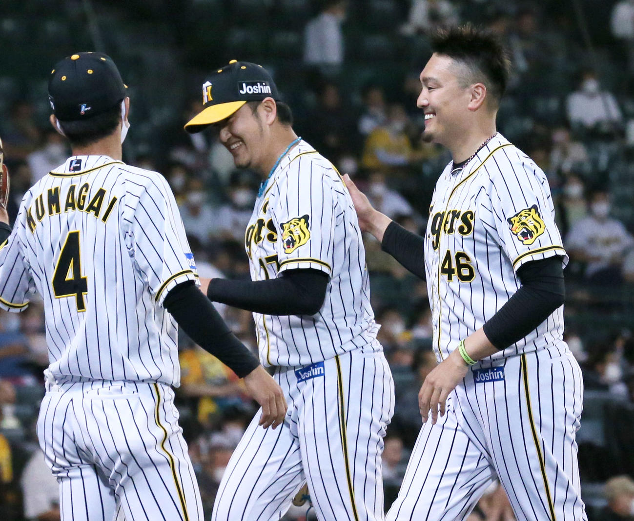 阪神対オリックス　6回途中で登板の岩貞（中央）は後続をキッチリ抑え秋山（右）の出迎えに笑顔を見せる（撮影・上山淳一）