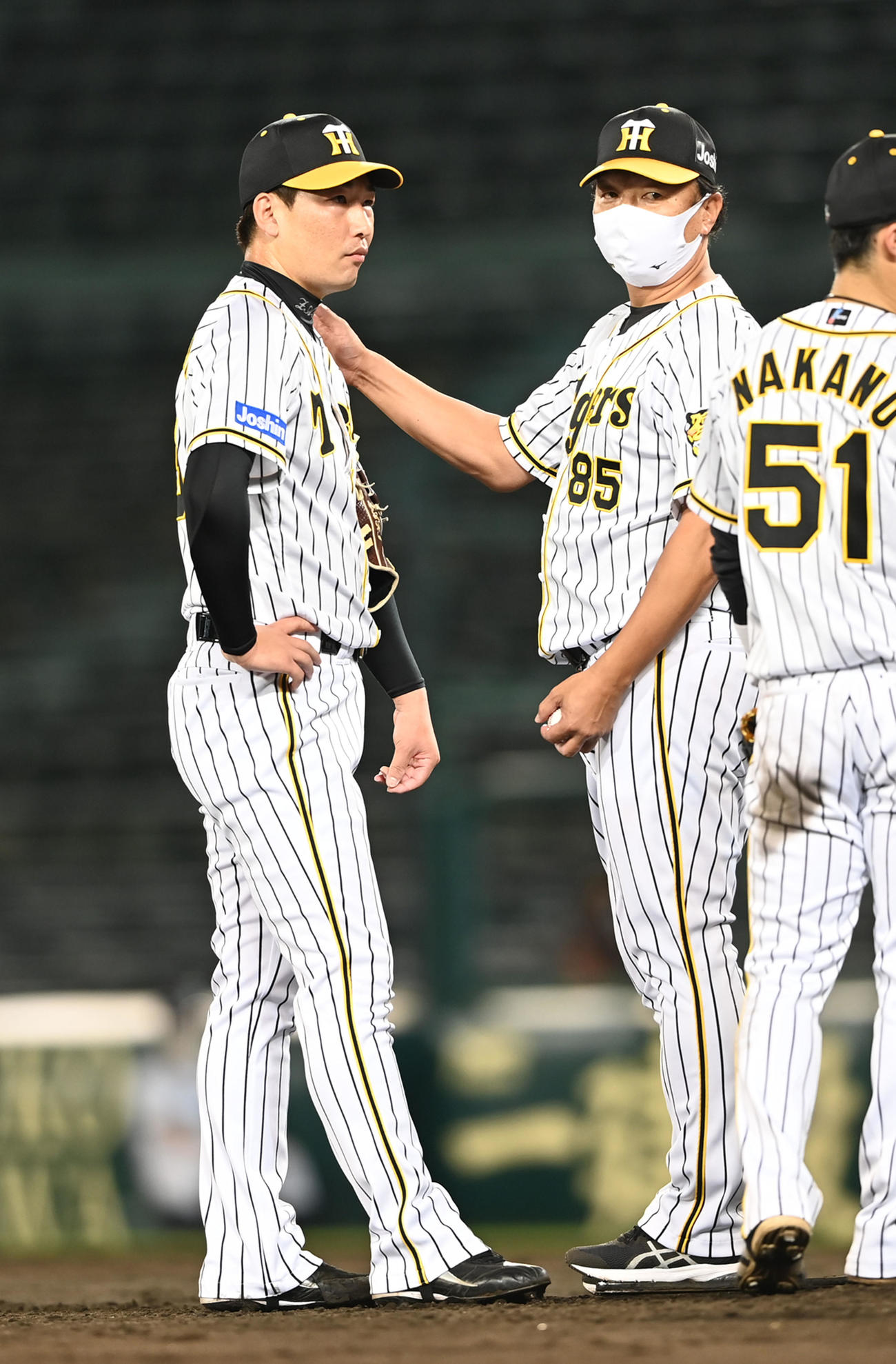 阪神対オリックス　8回、紅に2点本塁打を打たれ交代する岩崎優（左）は無念の表情で福原コーチにボールを渡す（撮影・前岡正明）