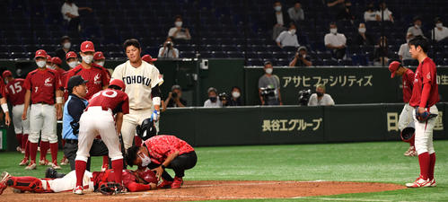 共栄大対東北福祉大 最後の打者のスイングしたバットが頭に当たり倒れた共栄大・釣谷捕手。右は完投勝利の赤坂(撮影・柴田隆二)