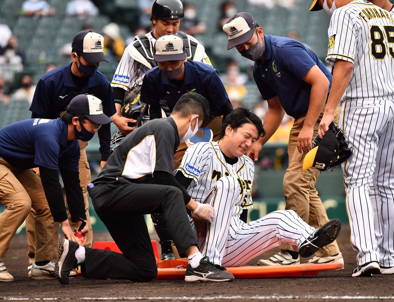 阪神対ソフトバンク　7回表ソフトバンク1死二、三塁、栗原陵矢の打球を処理し足を負傷し担架で運ばれる小林慶祐（撮影・上田博志）