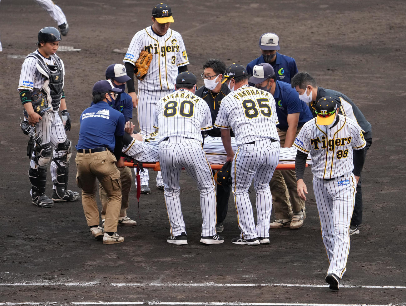 阪神対ソフトバンク　7回表ソフトバンク1死二、三塁、栗原の投ゴロを処理した時に足を痛めた小林（中央）は担架で運ばれる、右は矢野監督（撮影・清水貴仁）