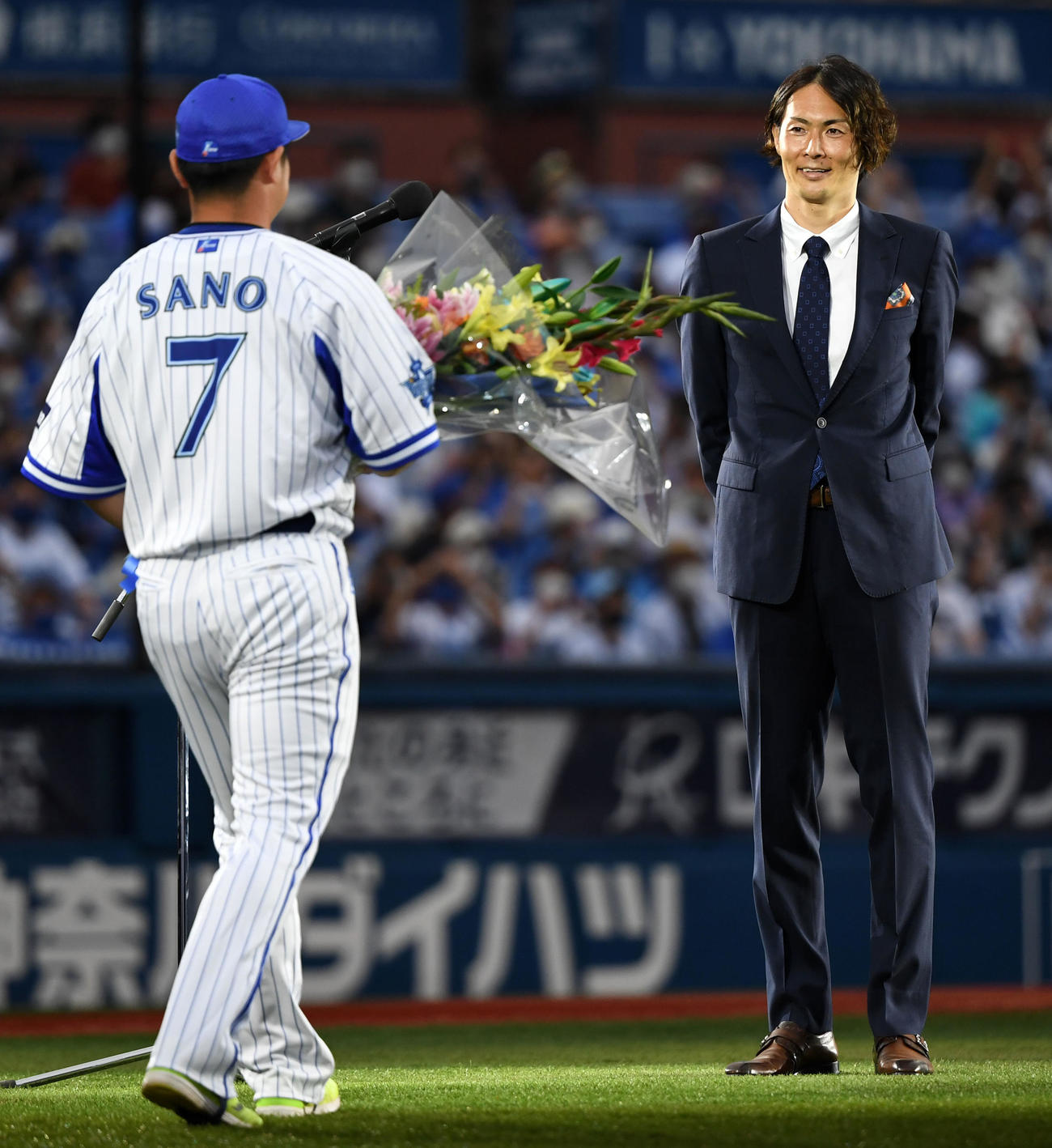 DeNA対ロッテ　引退セレモニーでDeNA佐野（左）から花束を受け取る石川雄洋氏（撮影・横山健太）