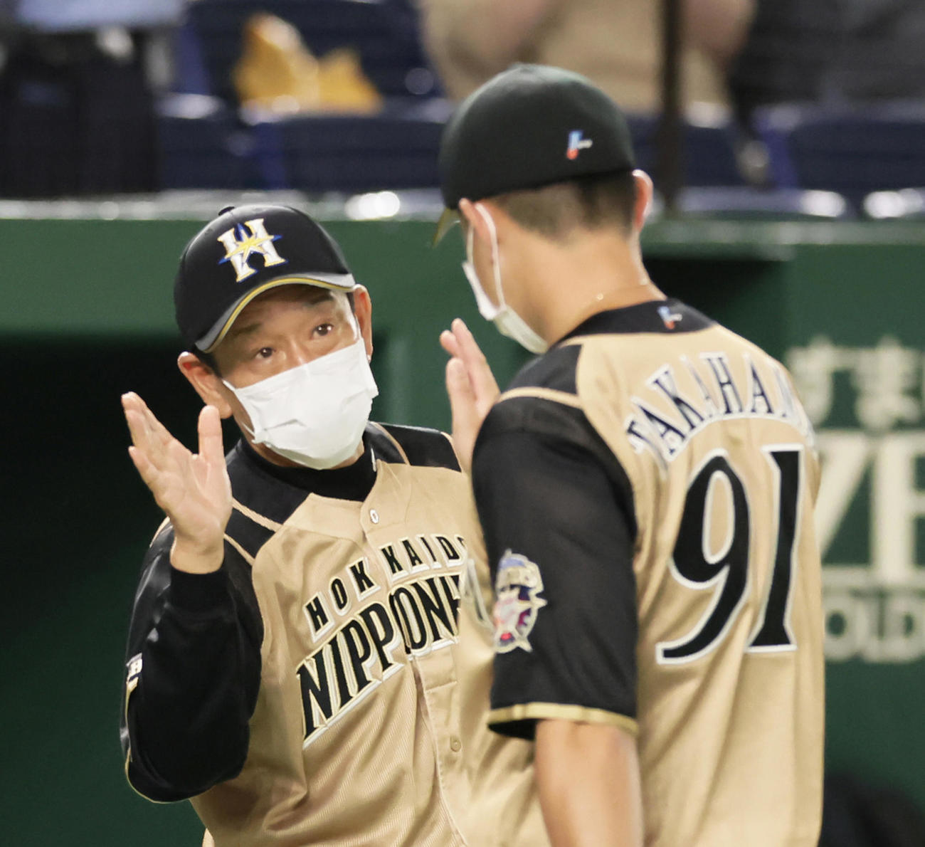 巨人対日本ハム　勝利した日本ハム栗山監督（左）は高浜をタッチで迎える（撮影・足立雅史）