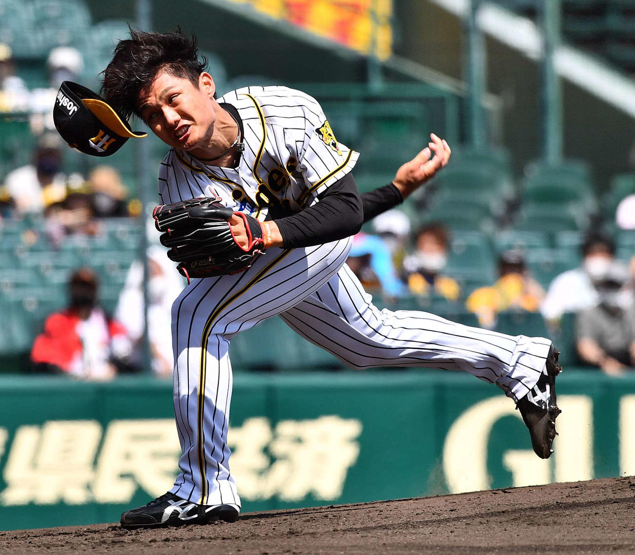阪神対ソフトバンク　帽子を飛ばしながら力投する阪神先発西純矢（撮影・上田博志）