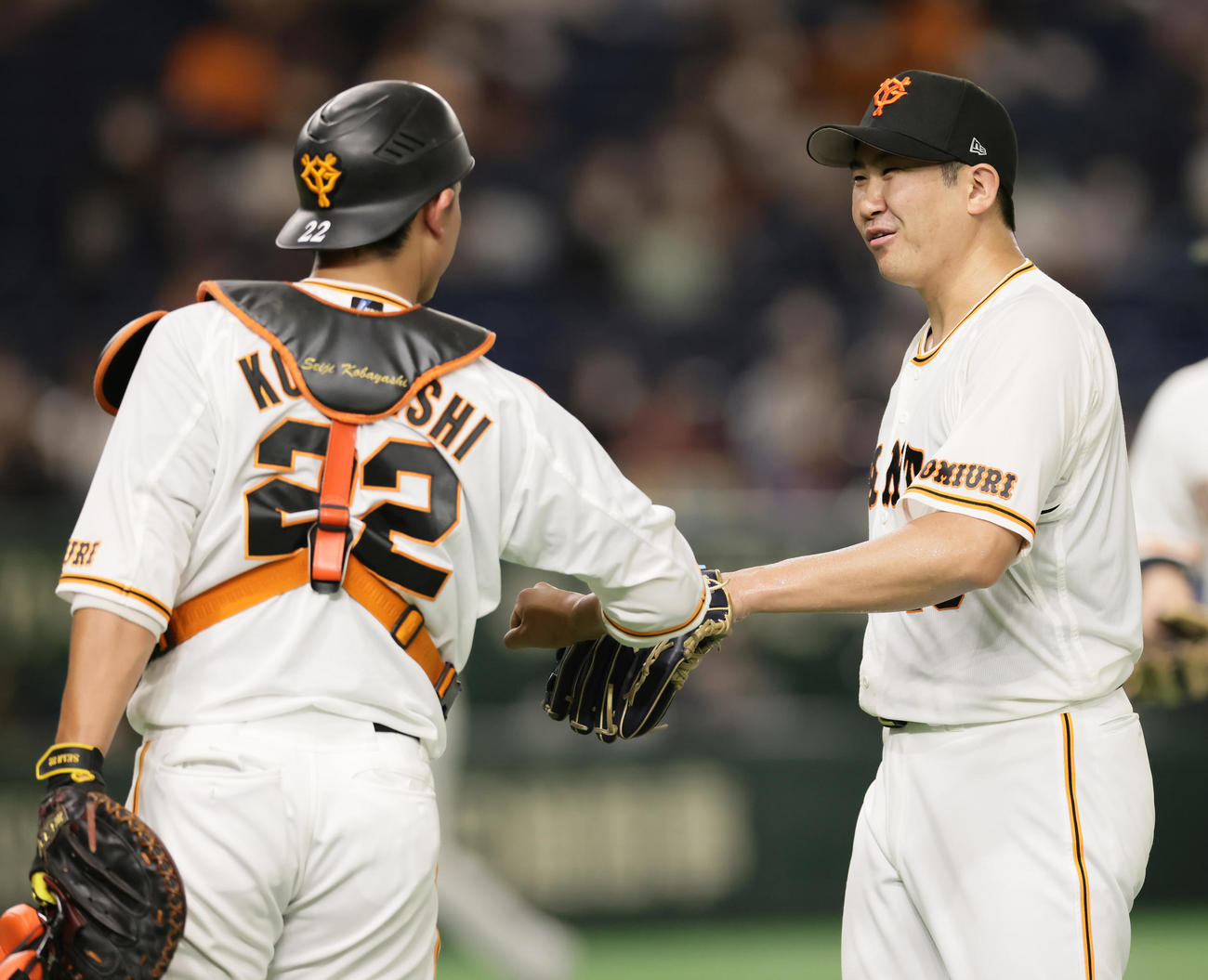 巨人対日本ハム　4回表日本ハムの攻撃を抑えた菅野（右）は小林とタッチを交わしながらベンチに戻る（撮影・足立雅史）