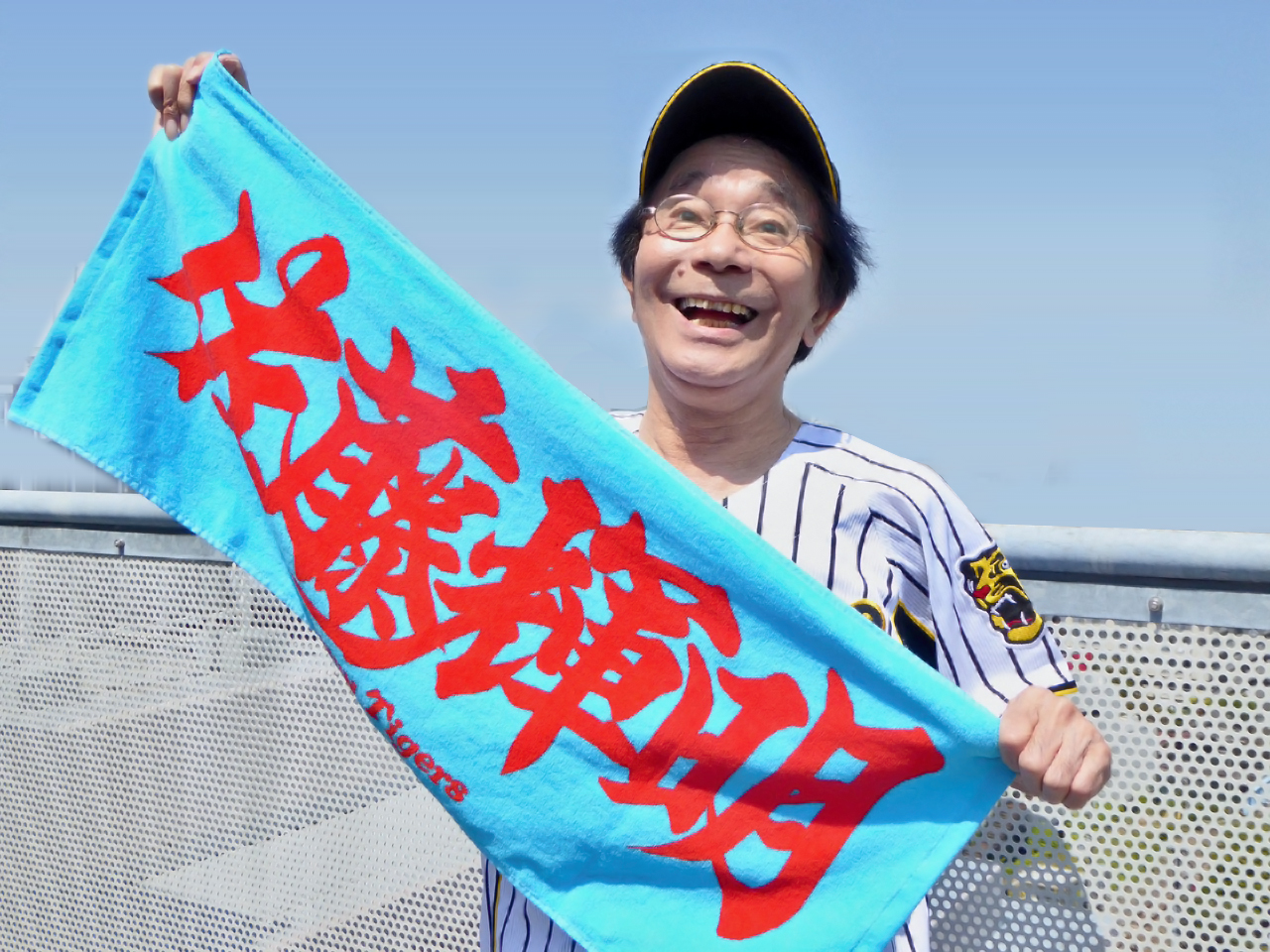 阪神佐藤輝のタオルを持ってエールを送る佐藤輝さん（オフィス天童提供）