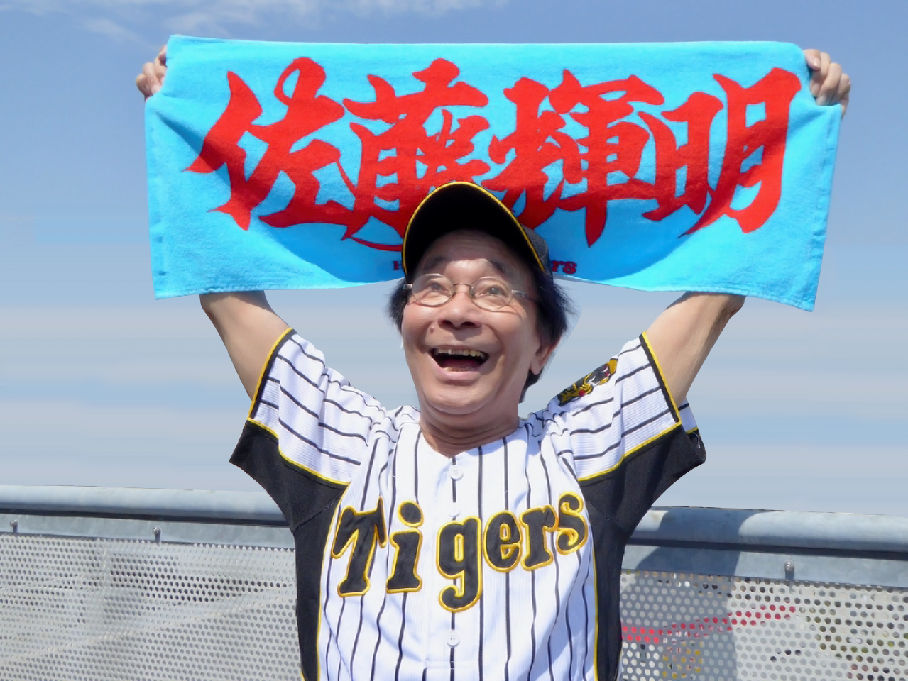 阪神佐藤輝のタオルを持ってエールを送る佐藤輝さん（オフィス天童提供）