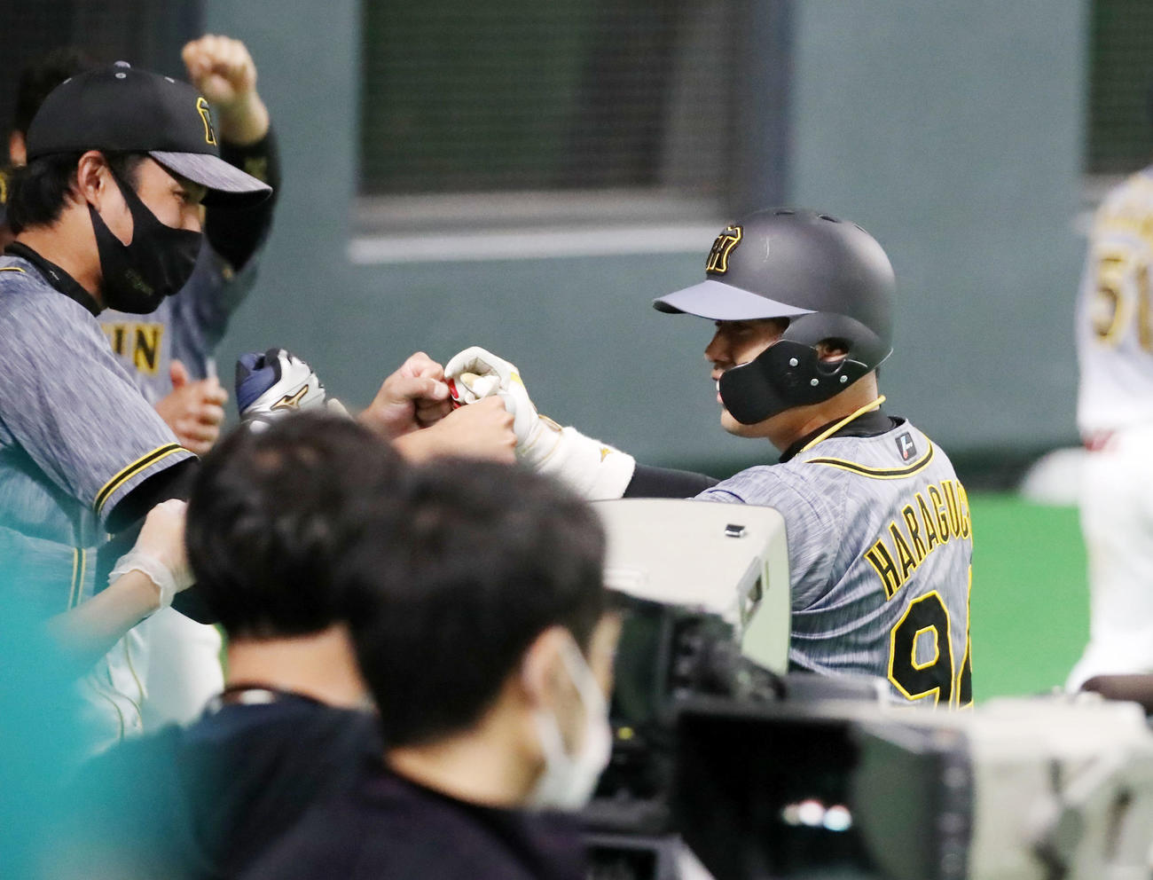 日本ハム対阪神　9回表阪神2死二塁、左越え適時二塁打を放ち代走が送られベンチに戻った代打原口（右）は笑顔の藤浪とタッチする（撮影・加藤哉）