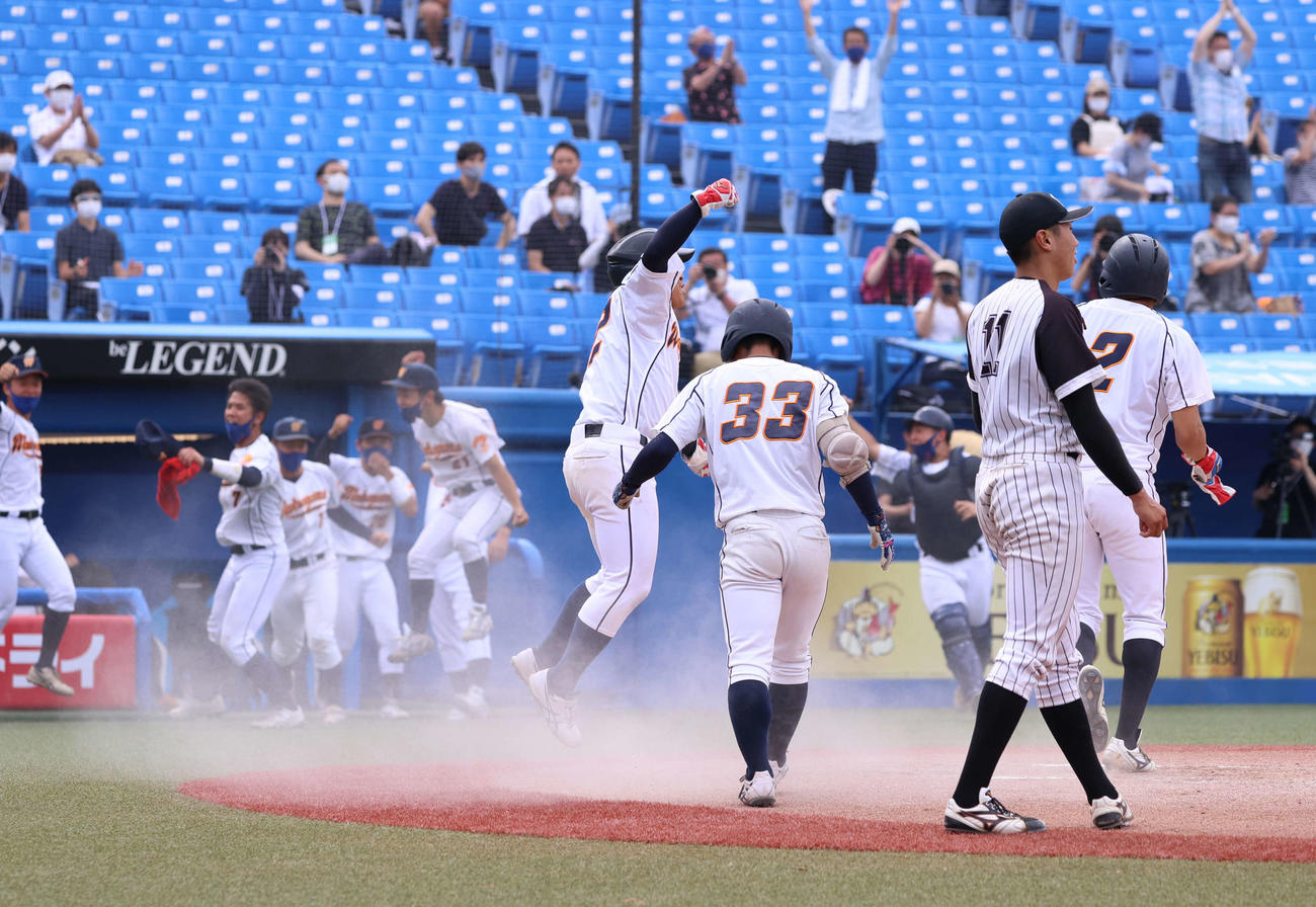 九産大対和歌山大　10回裏和歌山大1死満塁、柏田の内野安打で一気にサヨナラの生還を果たしジャンプして喜ぶ二塁走者の島本（中央）（撮影・河野匠）