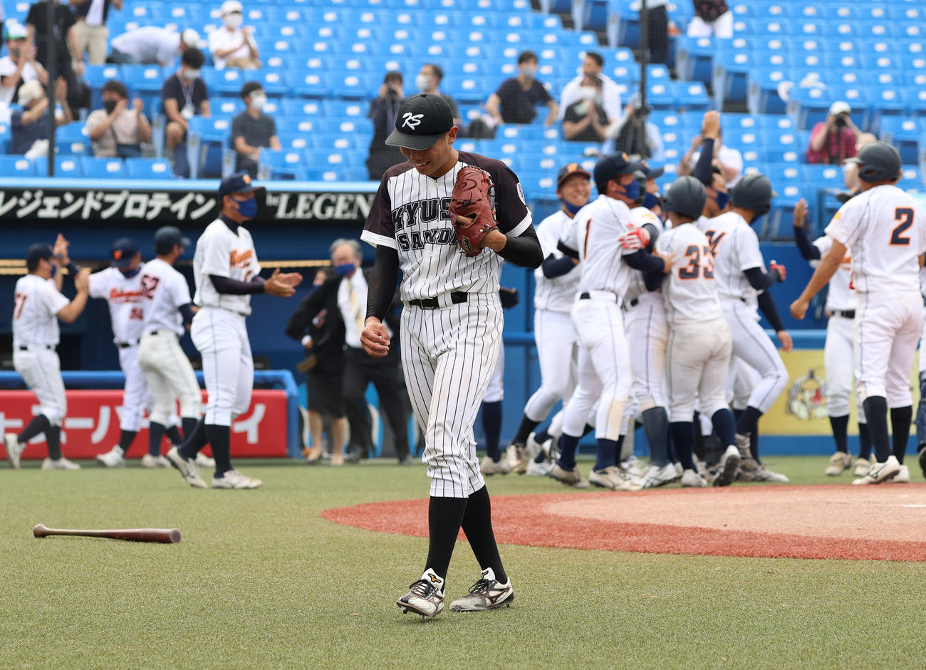 九産大対和歌山大　サヨナラ負けを喫し、歓喜の輪を作る和歌山大ナインを背にうつむく渡辺（撮影・河野匠）