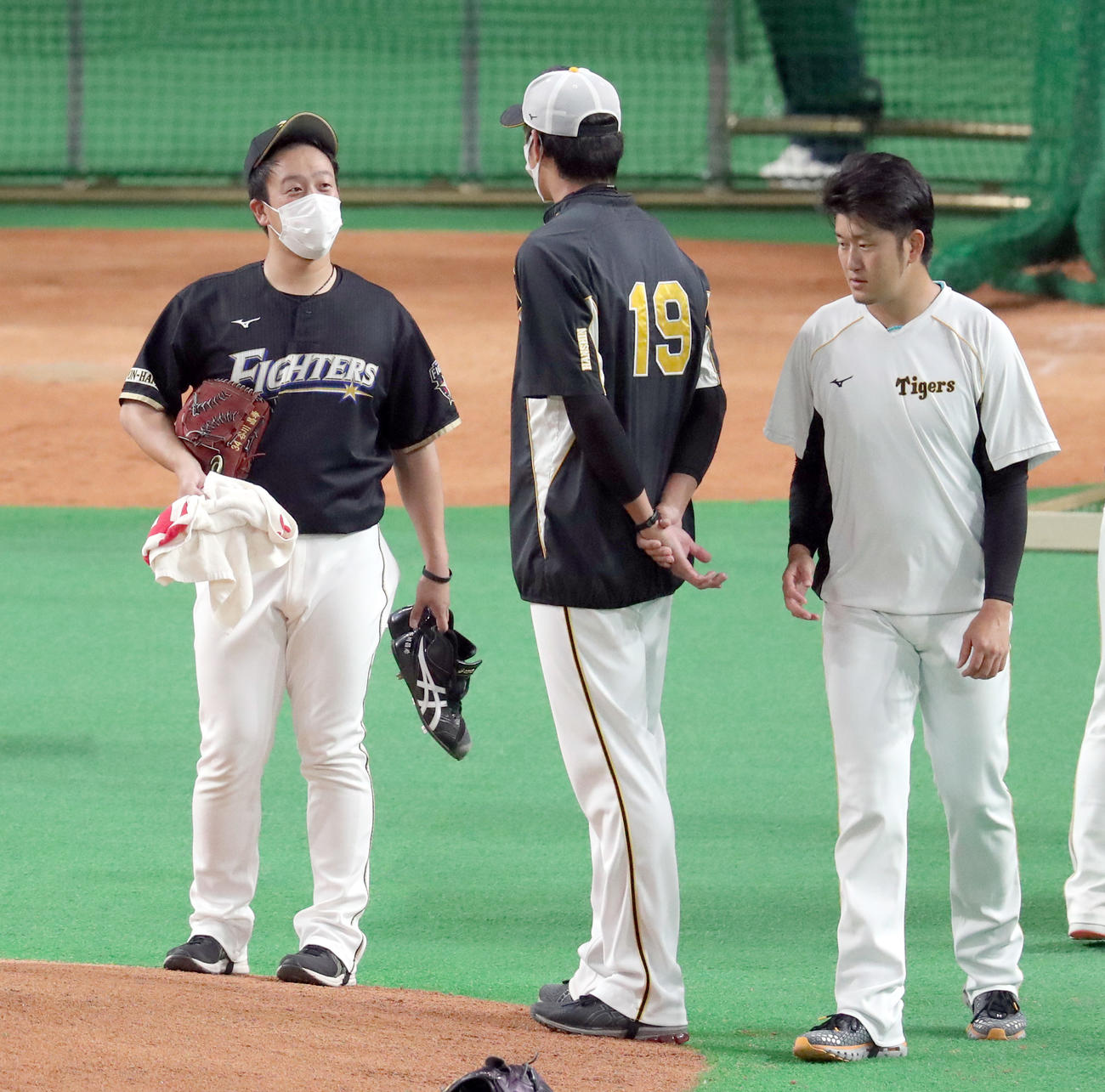 日本ハム対阪神　試合前、会話する日本ハム谷川（左奥）と阪神藤浪（撮影・佐藤翔太）