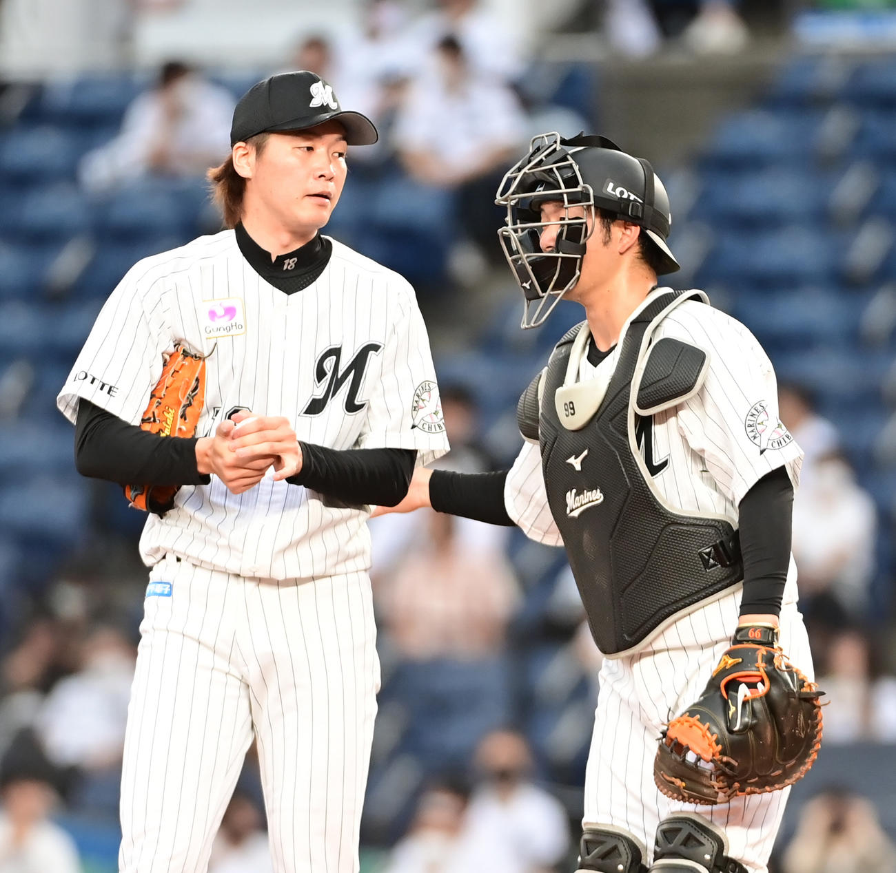 ロッテ対ヤクルト　1回表ヤクルト無死、立ち上がりに3連打で先制を許したロッテ先発の二木（左）は柿沼の激励を受ける（撮影・小沢裕）