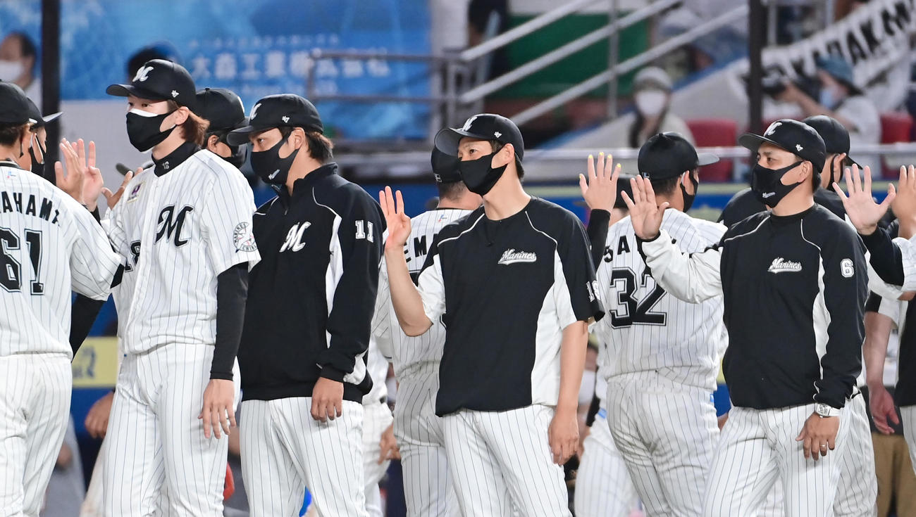 ロッテ対ヤクルト　今季3勝目を挙げたロッテ先発の二木（左）はナインとハイタッチ。右は井口監督（撮影・小沢裕）