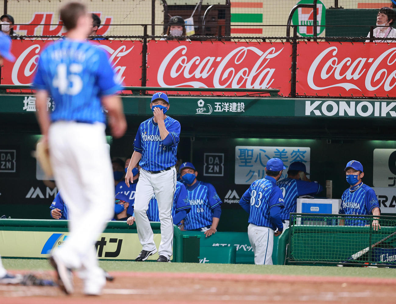 西武対DeNA 4回裏西武無死一、三塁、山川の投手強襲の適時内野安打でピープルズ（手前）が本塁に悪送球し、厳しい表情で見つめる三浦監督（右）（撮影・浅見桂子）