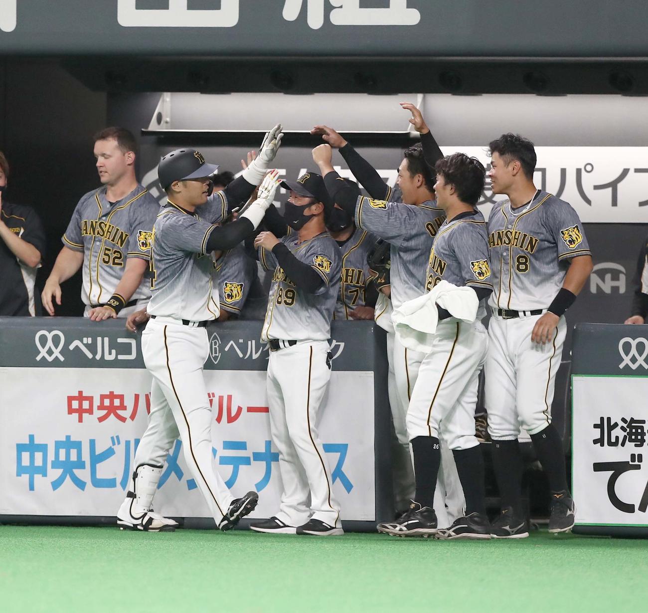日本ハム対阪神　9回表、適時二塁打を放った原口（左）を出迎える阪神ナイン（撮影・黒川智章）