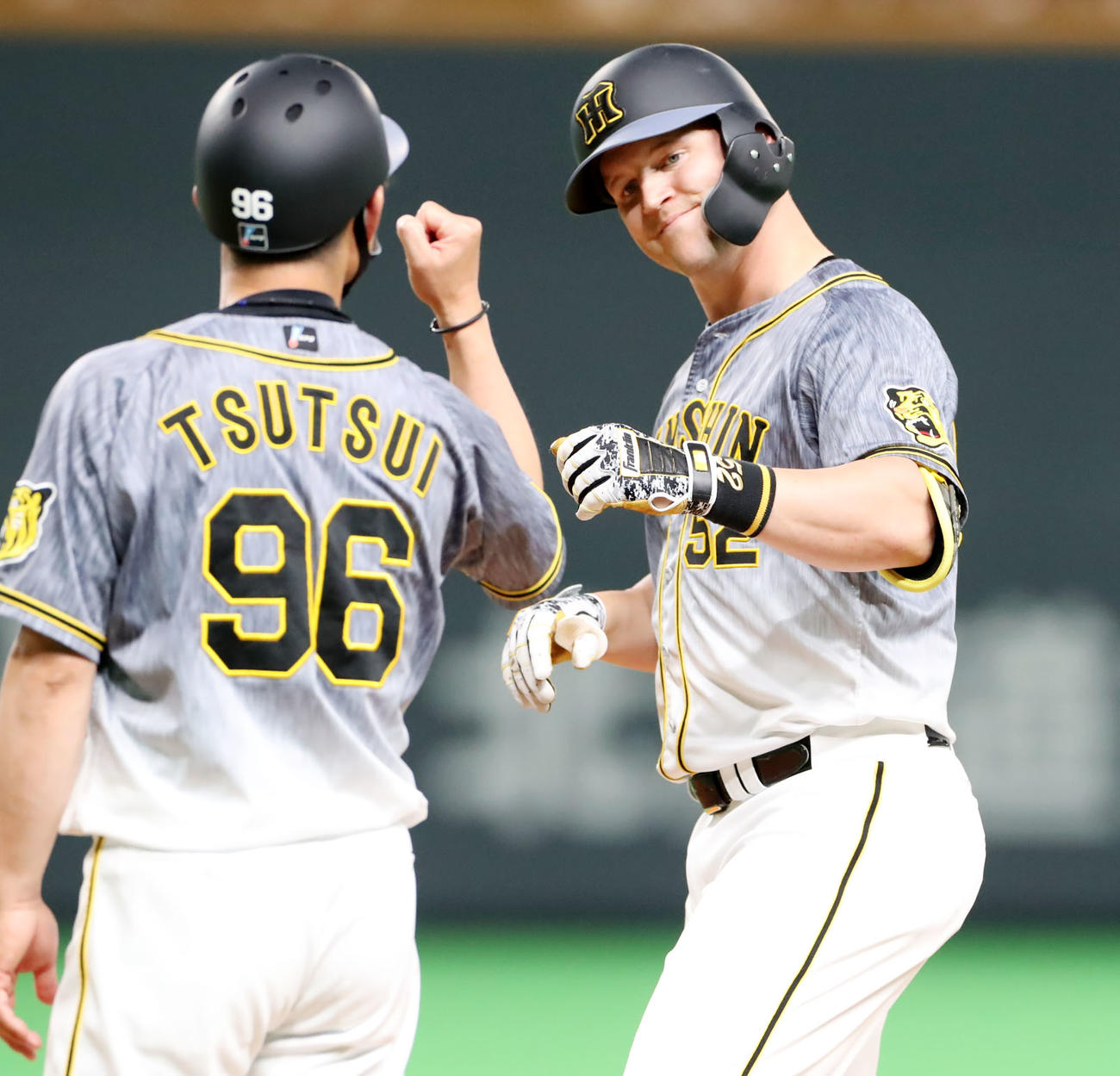 日本ハム対阪神　5回表阪神1死二塁、サンズは中前適時打を放ち筒井コーチとタッチ（撮影・加藤哉）