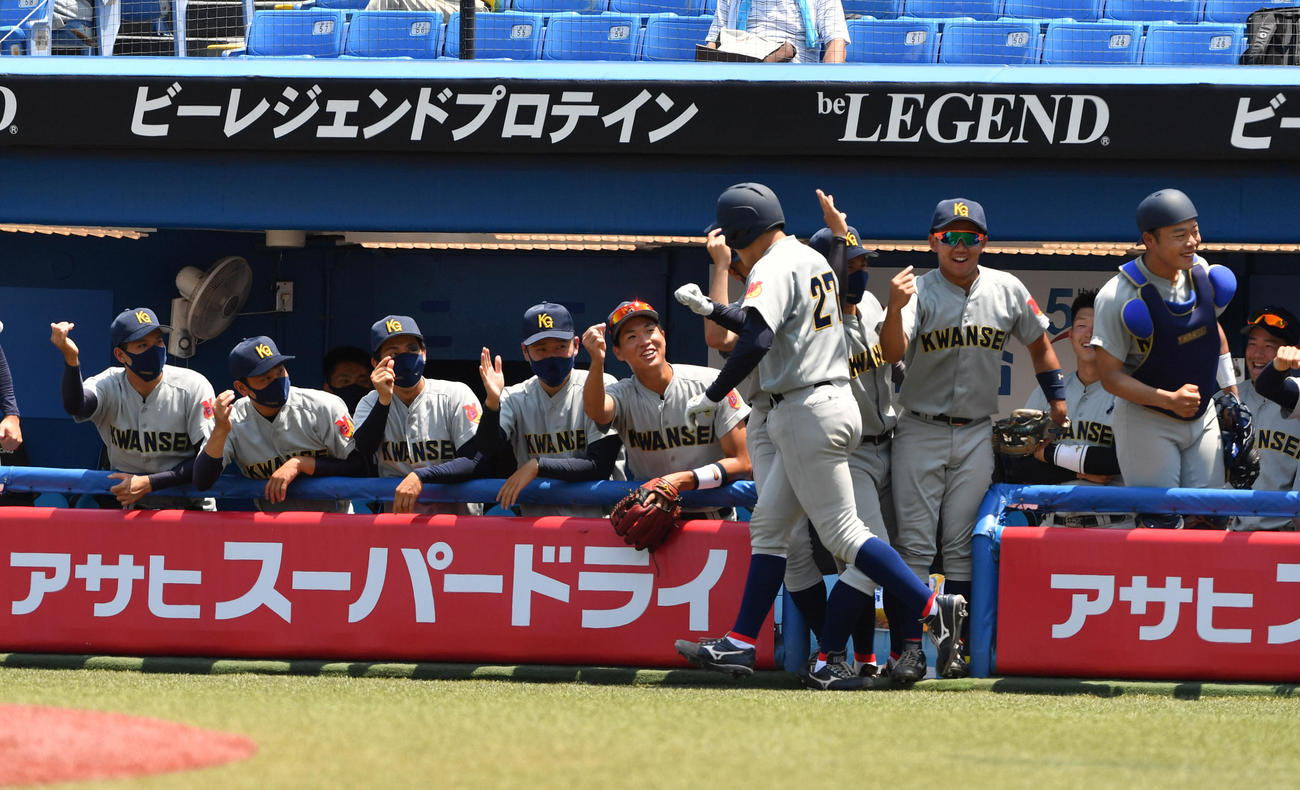 準々決勝、慶大対関学大　2回裏関学大2死、佐藤は左越えに本塁打を放ちナインの出迎えを受ける（撮影・柴田隆二）