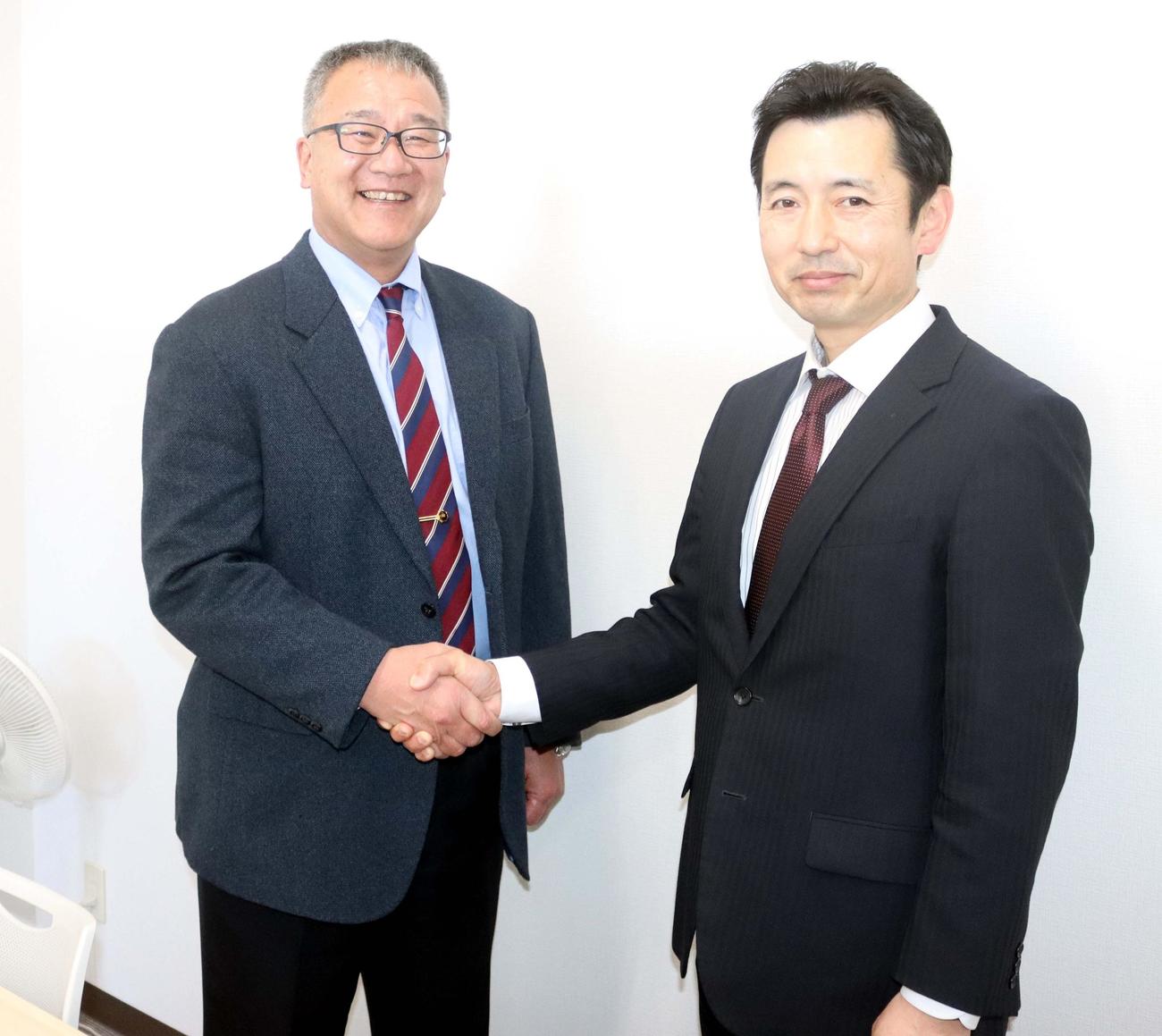 ホーネッツ・レディーズの高橋監督と握手する石井GM（左）（撮影・永野高輔）