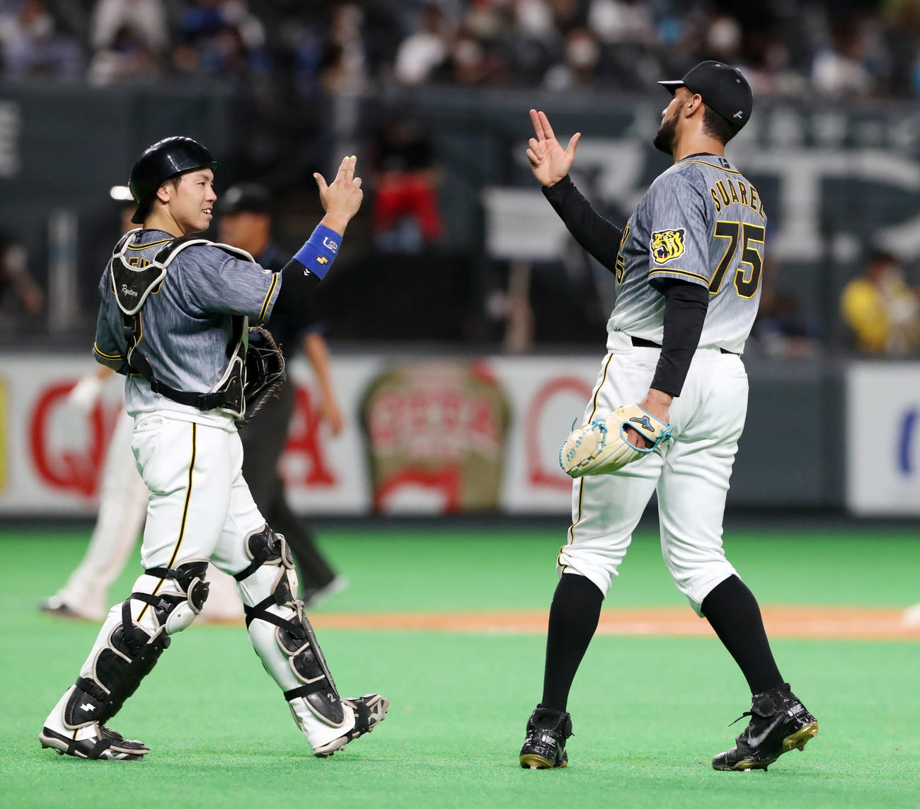 日本ハム対阪神　9回裏日本ハム1死一、二塁、スアレスは野村を二ゴロ併殺に打ち取り梅野（左）とタッチする（撮影・加藤哉）