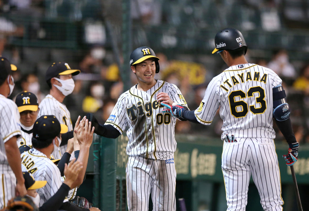 阪神対ソフトバンク　5回裏阪神2死二塁、山本（右から2人目）は遠藤の左適時二塁打で生還しナインの出迎えに笑顔を見せる（撮影・上山淳一）