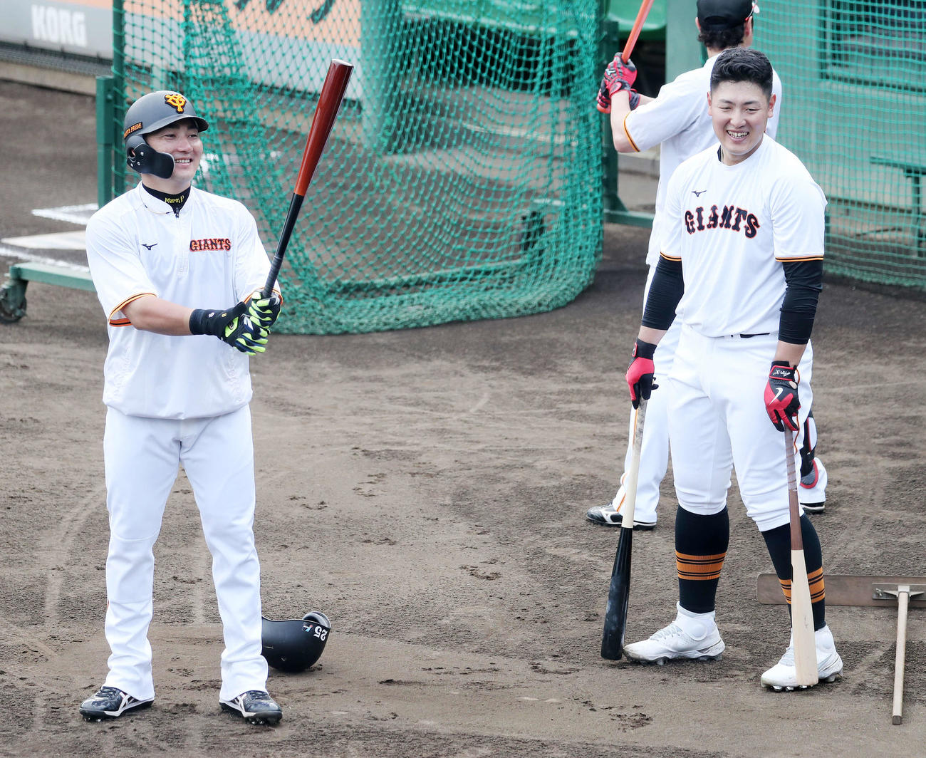練習中、笑顔を見せる巨人丸（左）と岡本和（撮影・鈴木正人）