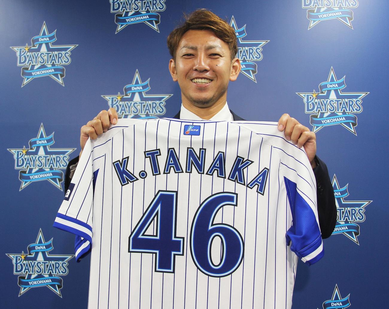左肘手術から復帰して支配下選手登録を結んだDeNA田中健は背番号「46」のユニホームを手に笑顔を見せる（球団提供）
