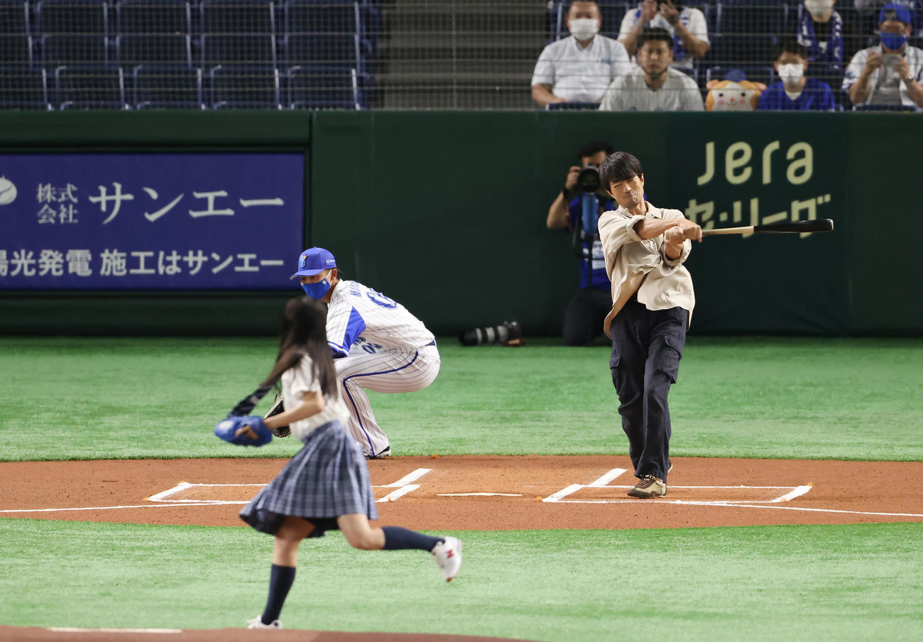 DeNA対広島　試合前、始球式で関水渚（手前）の投球にフルスイングする仲村トオル（撮影・垰建太）