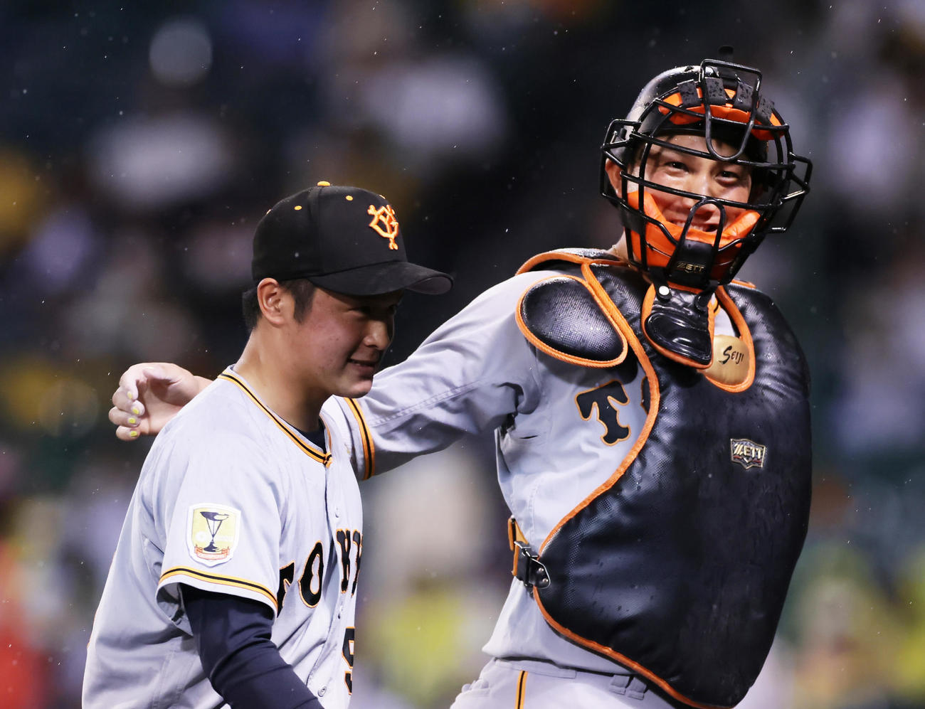 阪神対巨人　8回から登板した巨人戸田（左）の肩を笑顔でたたく小林（撮影・足立雅史）