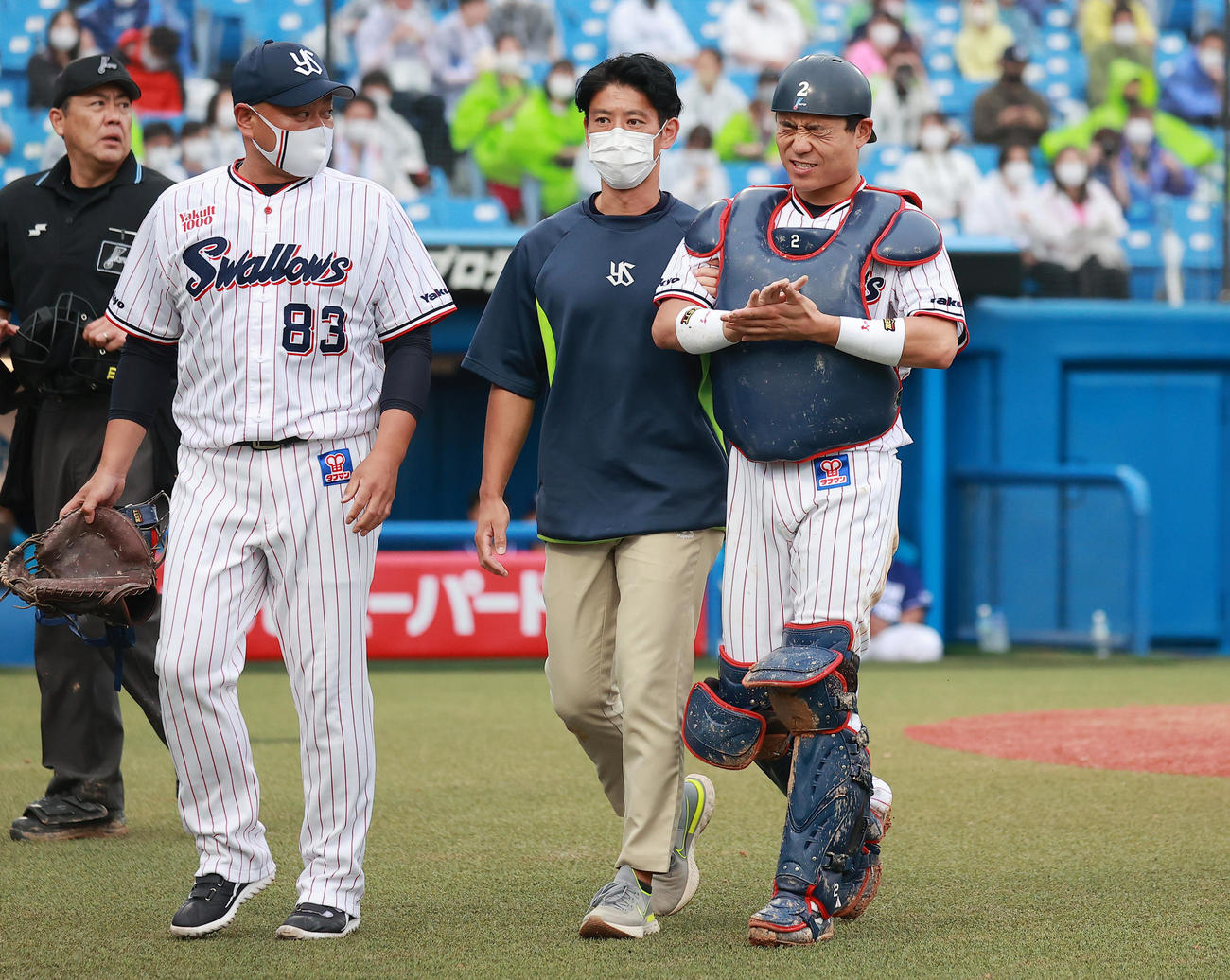 ヤクルト対中日　8回表中日無死二塁、福田の打球を受け、治療のためベンチに向かう中村（右）。左は衣川バッテリーコーチ（撮影・野上伸悟）