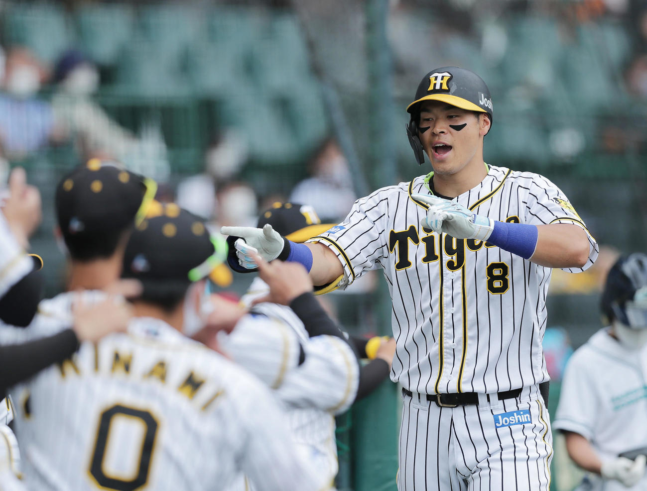 阪神対巨人　6回裏阪神2死、左越え本塁打を放ちナインに迎えられる佐藤輝（右）（撮影・前田充）