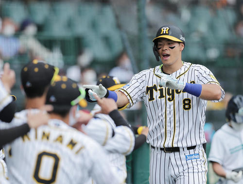 阪神対巨人　6回裏阪神2死、左越え本塁打を放ちナインに迎えられる佐藤輝（右）（撮影・前田充）