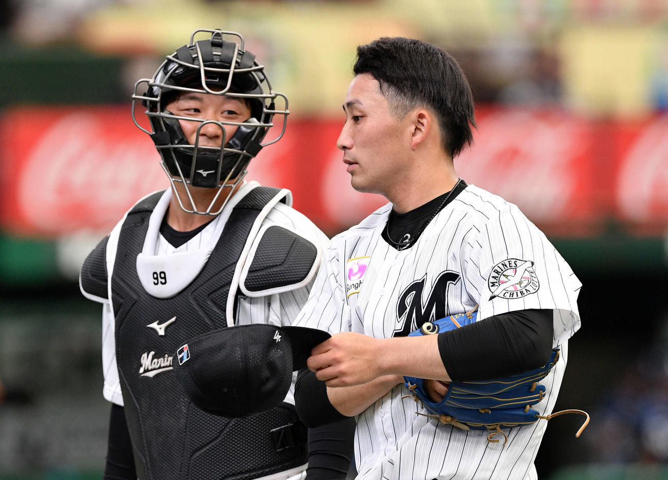 西武対ロッテ　1回を投げ終えロッテ柿沼（左）と引き揚げる小島（撮影・滝沢徹郎）