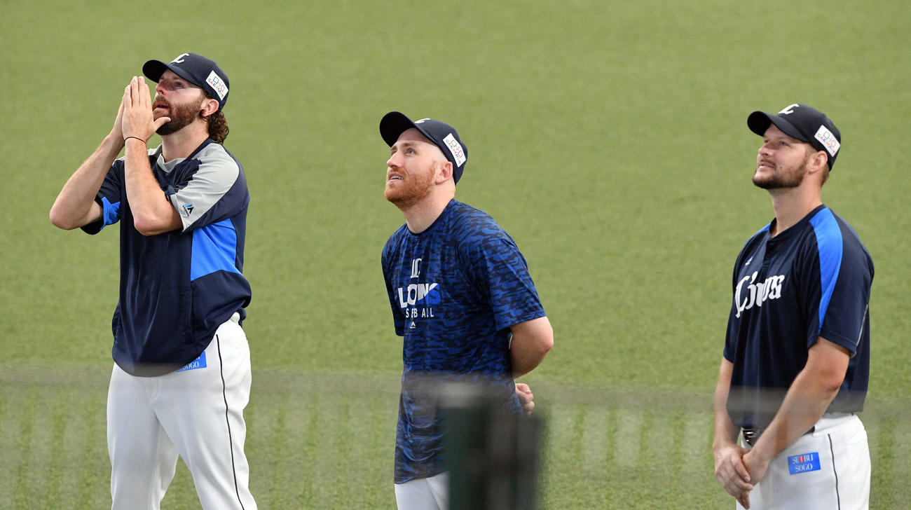 西武対ロッテ　試合前練習中にサプライズで流された家族からのビデオメッセージを見つめる、左から西武ニール、ギャレット、ダーモディ（撮影・滝沢徹郎）