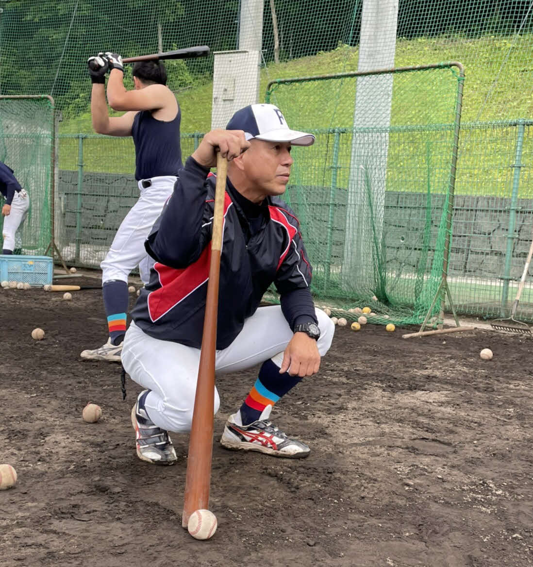 打撃練習を真剣な表情でチェックする福井工大・町田総合コーチ（福井工大硬式野球部提供）